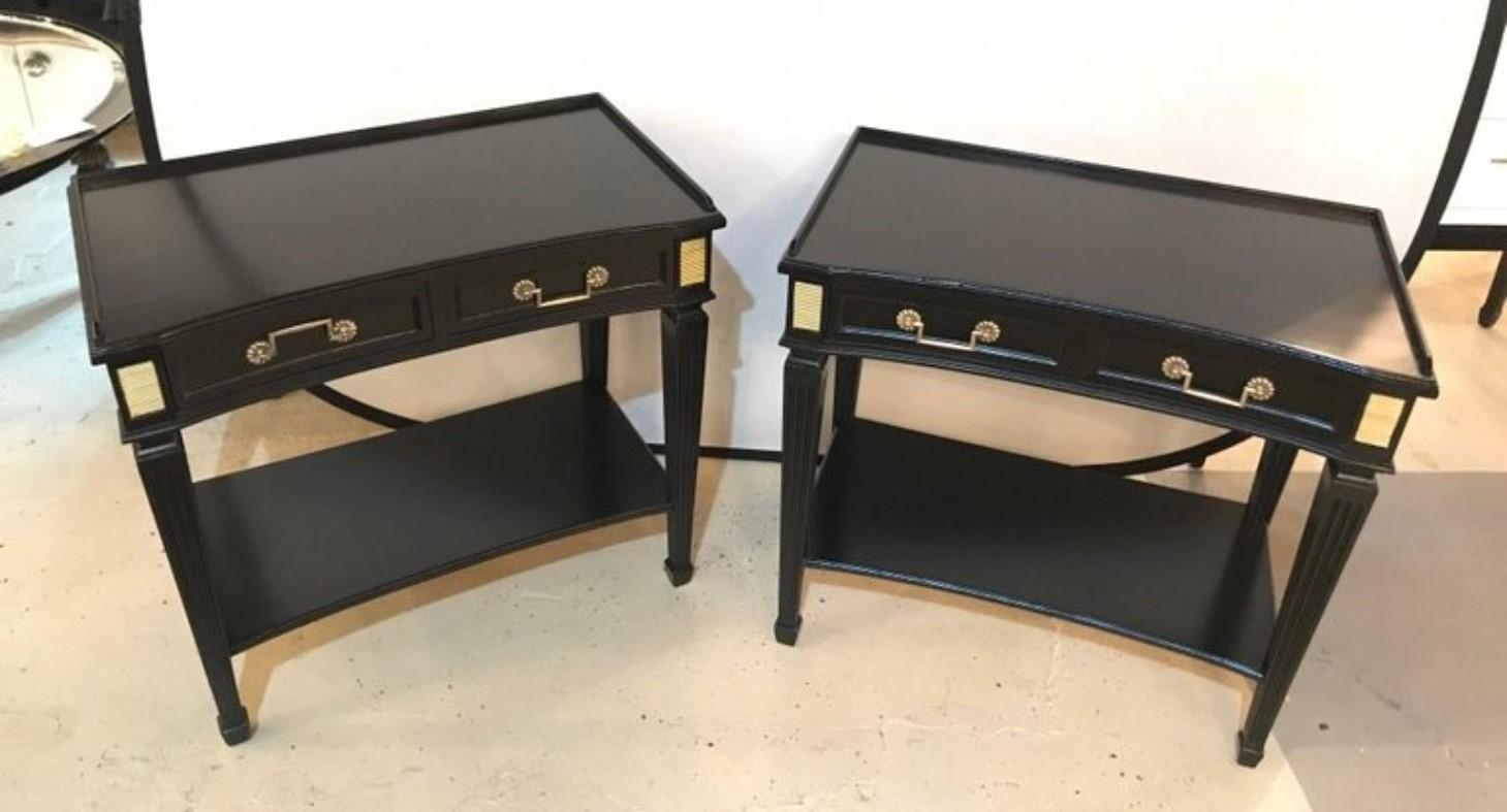 Pair of Hollywood Regency Jansen Style ebonized one drawer end tables or bedside stands. Each having oak secondary and an ebony finish with bronze mounts and framed tops.