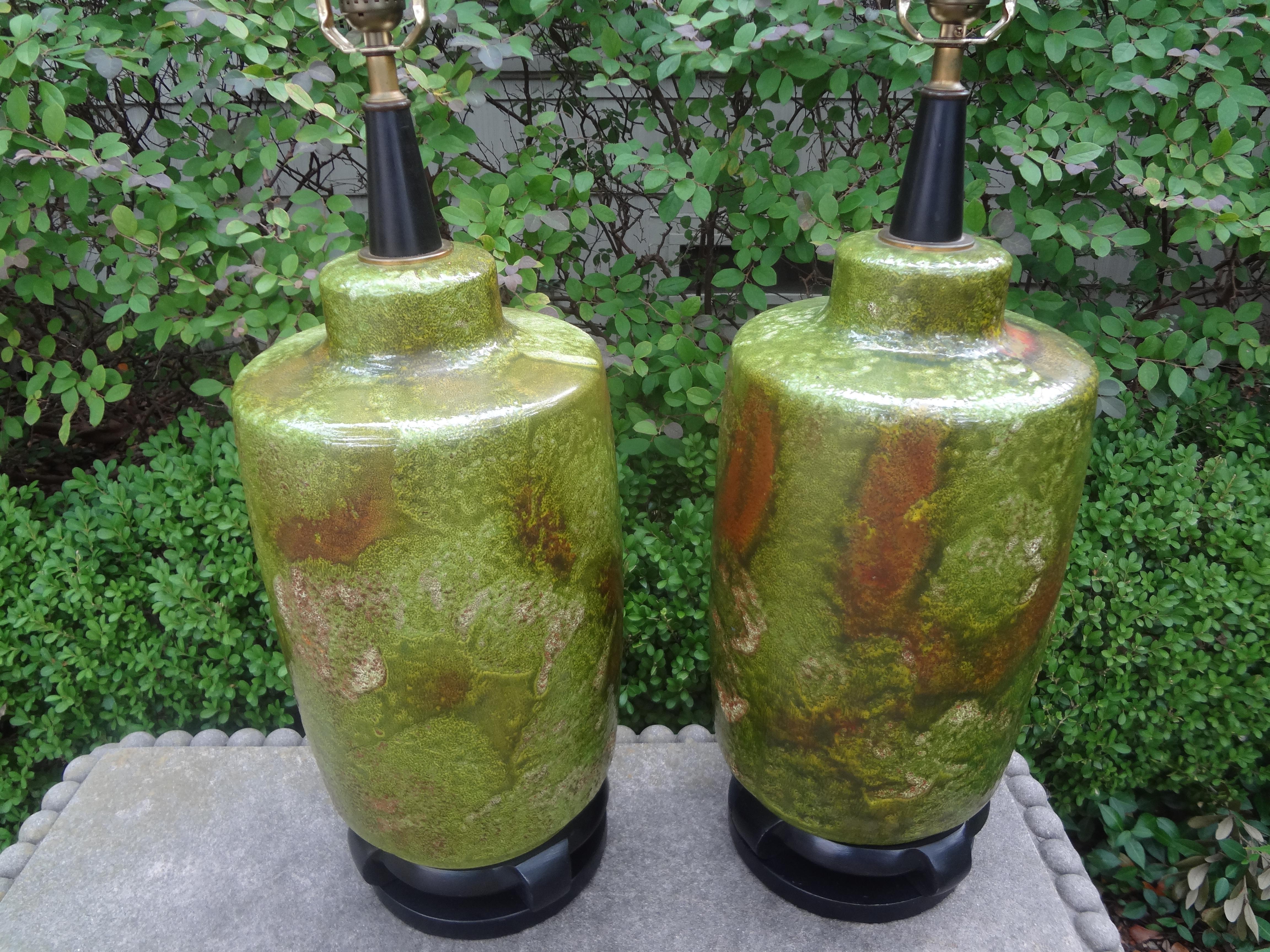Pair of Hollywood Regency lamps attributed To James Mont. this pair of beautifully glazed ceramic lamps in a stunning shade of green mounted on an Asian Modern base. These midcentury lamps are newly wired with new sockets for the U.S. market.
