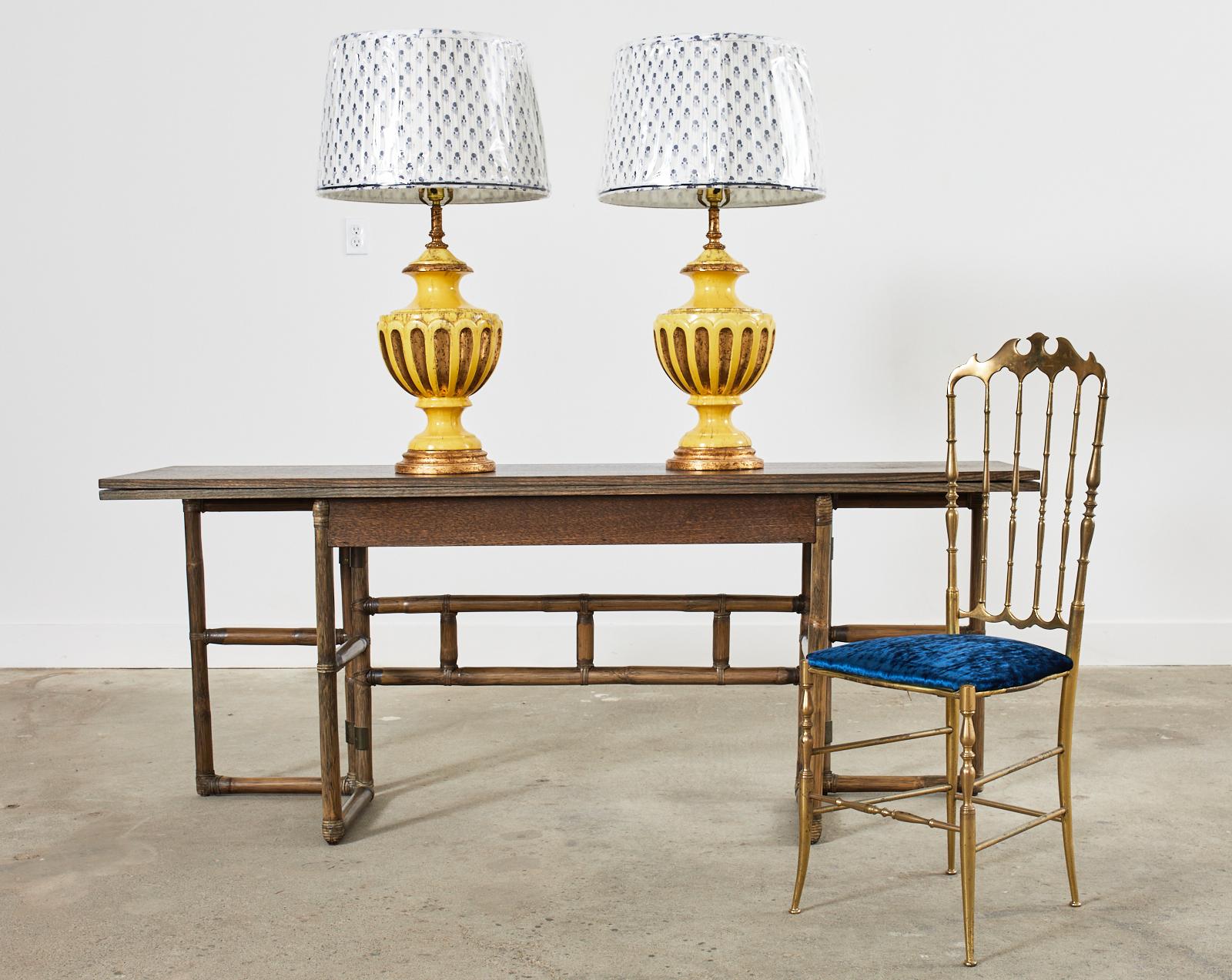 Fantastique paire de lampes de table en porcelaine de style Hollywood Regency du milieu du siècle dernier par le Studio Nardini de Californie. Les lampes présentent une étonnante forme d'urne à glaçure jaune avec des accents dorés appliqués. Les