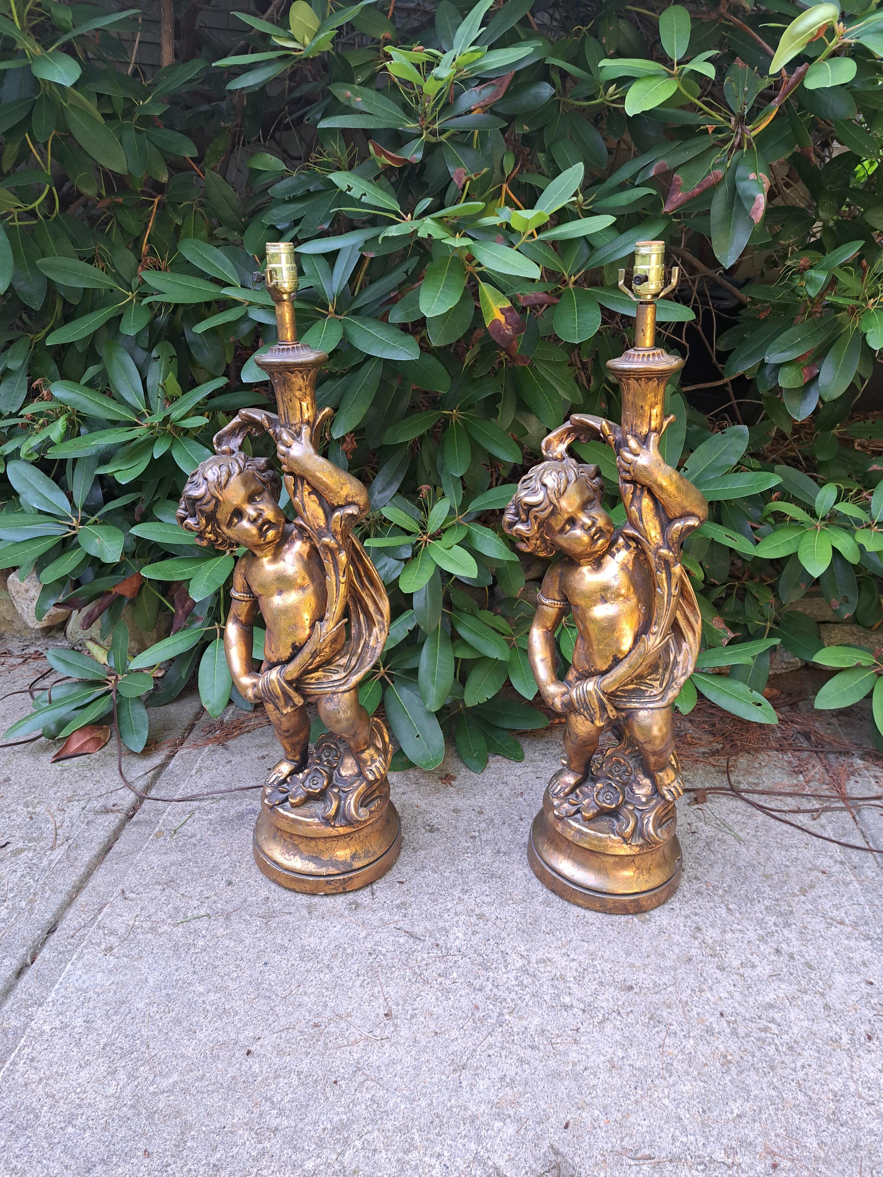 Coppia di lampade da tavolo a cherubino dorate Hollywood Regency extra large con paralumi personalizzati abbinati. Le lampade in gesso pesante sono altamente dettagliate e finemente fuse. I paralumi dorati personalizzati completano il look regency.