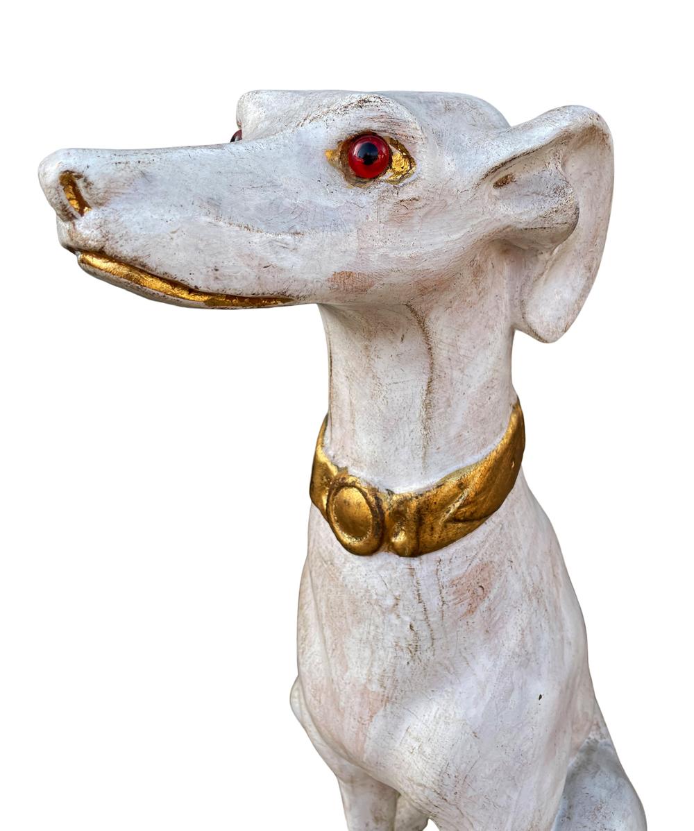 A matched pair of Italian Greyhound statues from Italy circa 1970's. These feature glazed ceramic construction with gold gilding and glass eyes. Price includes the pair as shown.