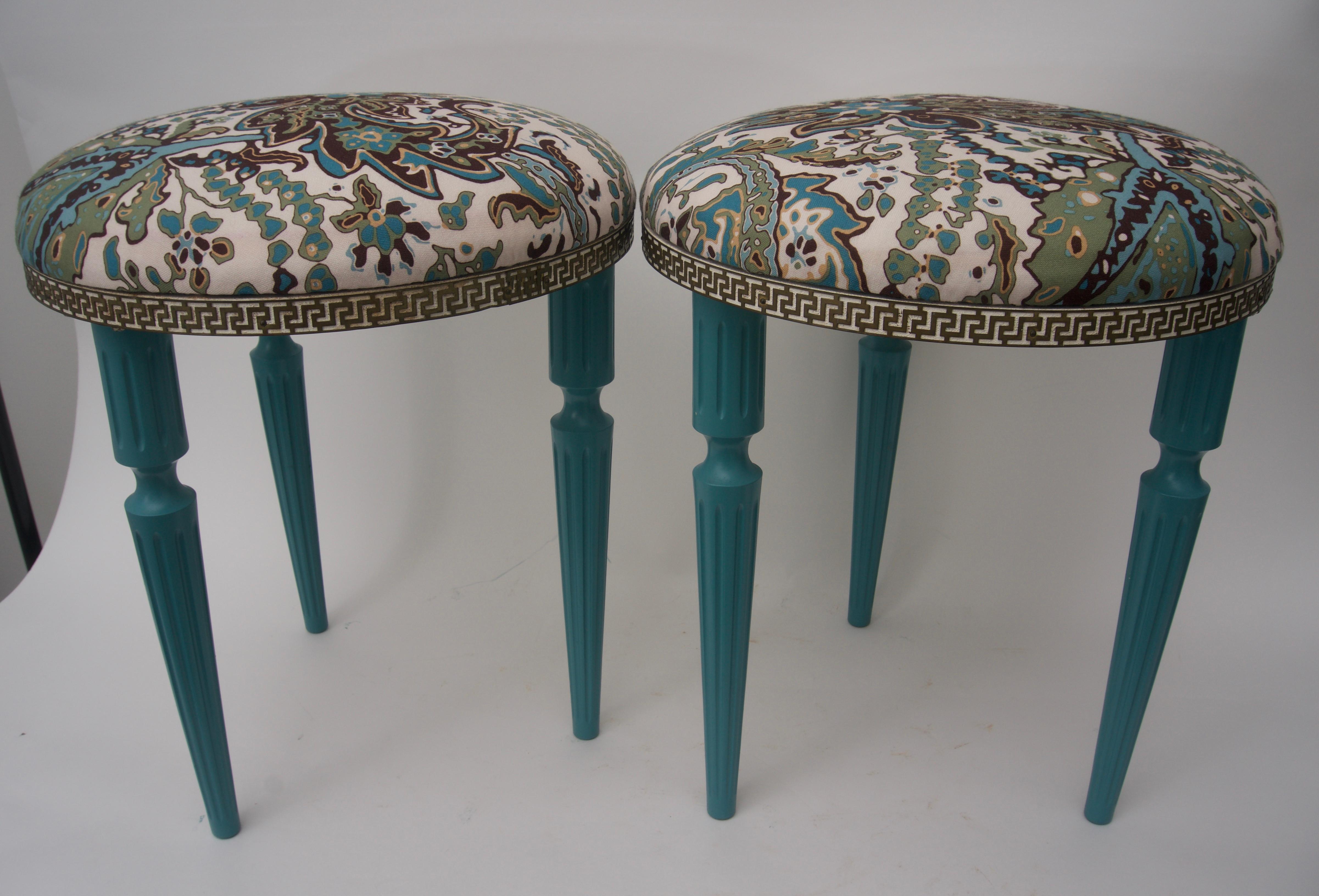 This stylish pair of stools are in the Hollywood Regency vain with there Louis XVI style frames that have been lacquered in a deep turquoise with a woven floral fabric seat which is bordered with a pierced metal band.
