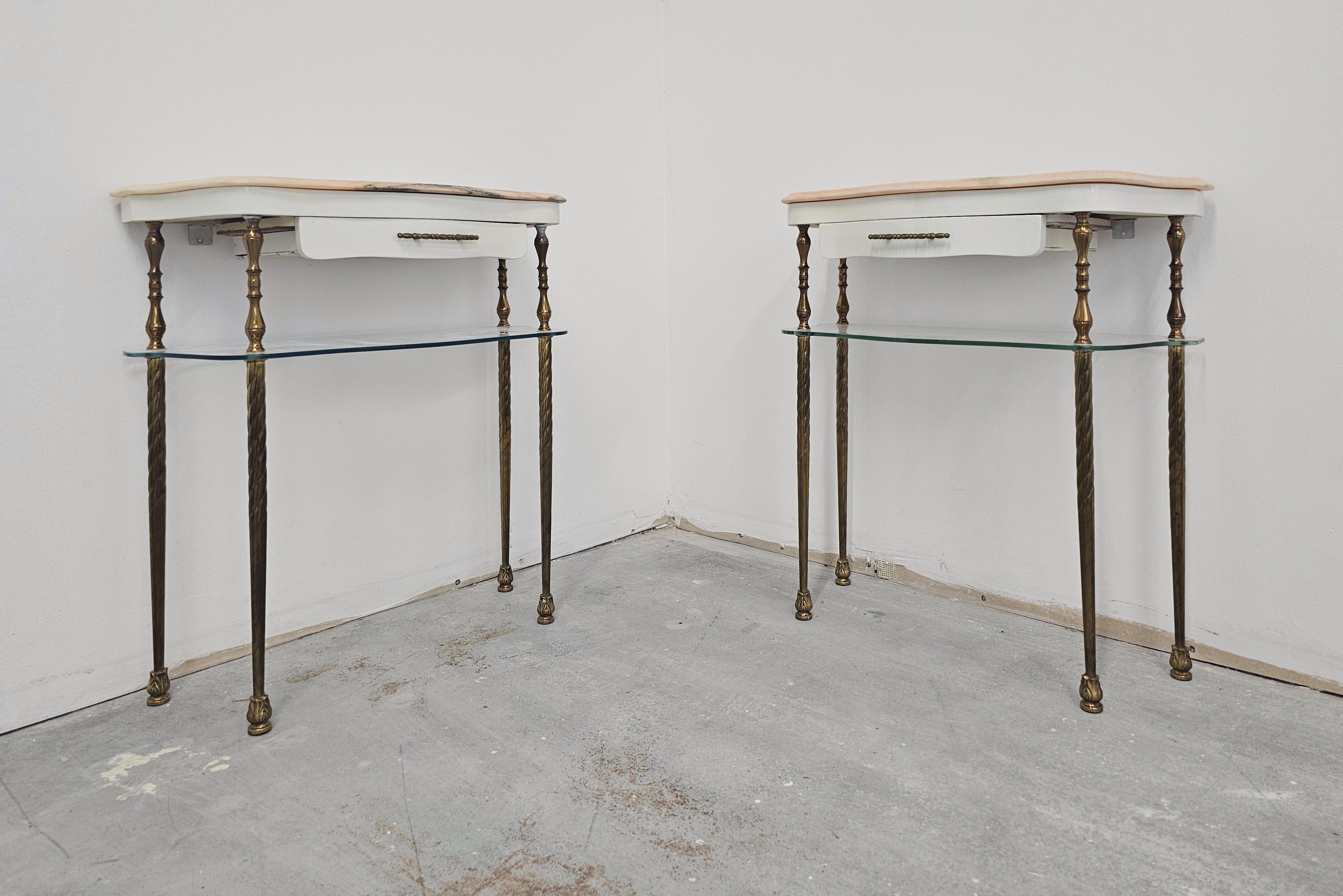 In this listing you will find a pair of stunning and very elegant Hollywood Regency Nightstands. They are made in bronze, with a pink marble top and a glass shelf. Each has a tiny drawer with the brass hardware. Made in Italy in 1950s.

Very good
