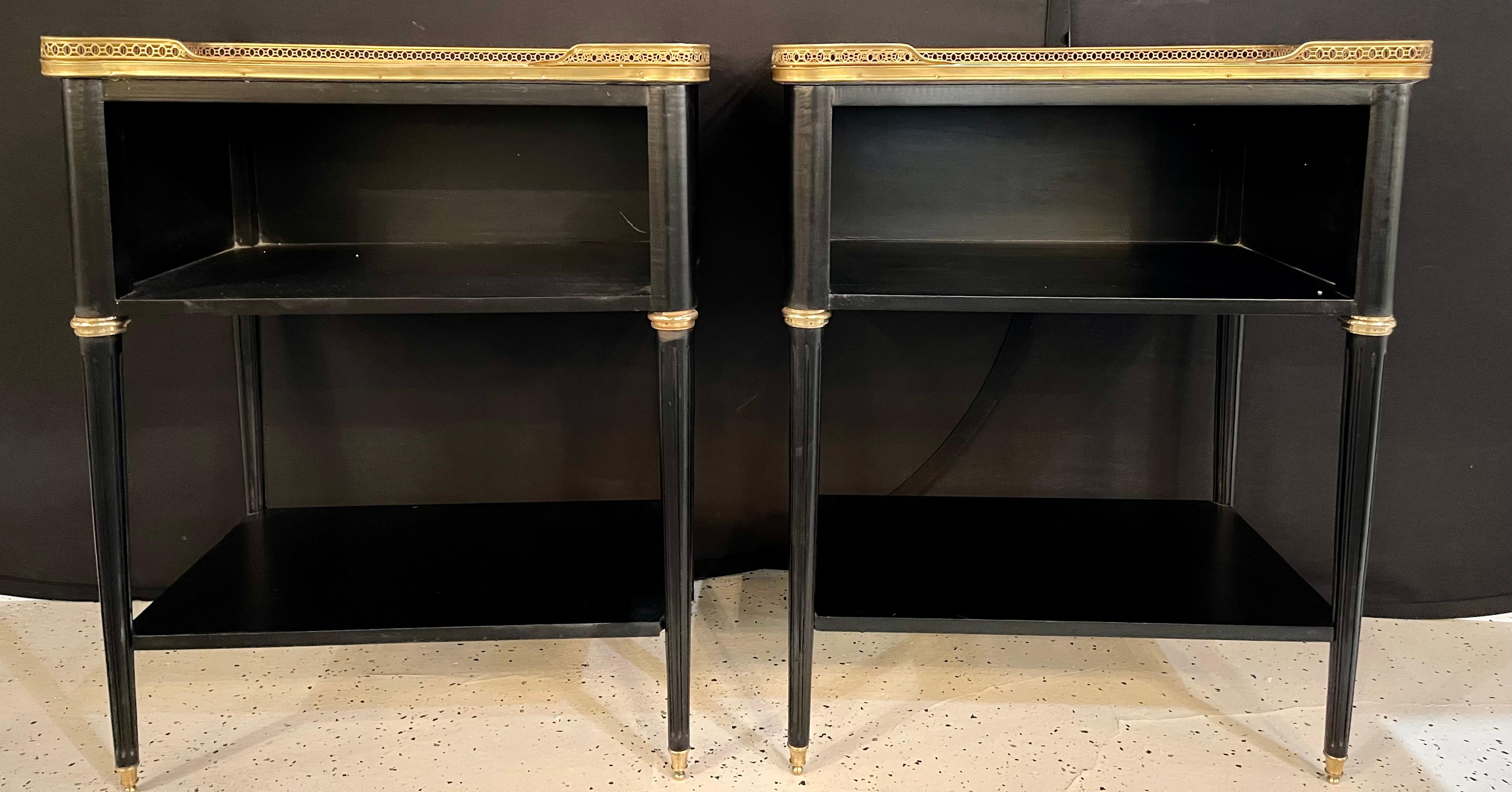 Pair of Hollywood Regency nightstands or end tables in the manner of Jansen. These finely crafted open end tables are simply stunning. The Carrara white and gray veined marble tops have rounded corners and sit inside a pierced bronze raised gallery.