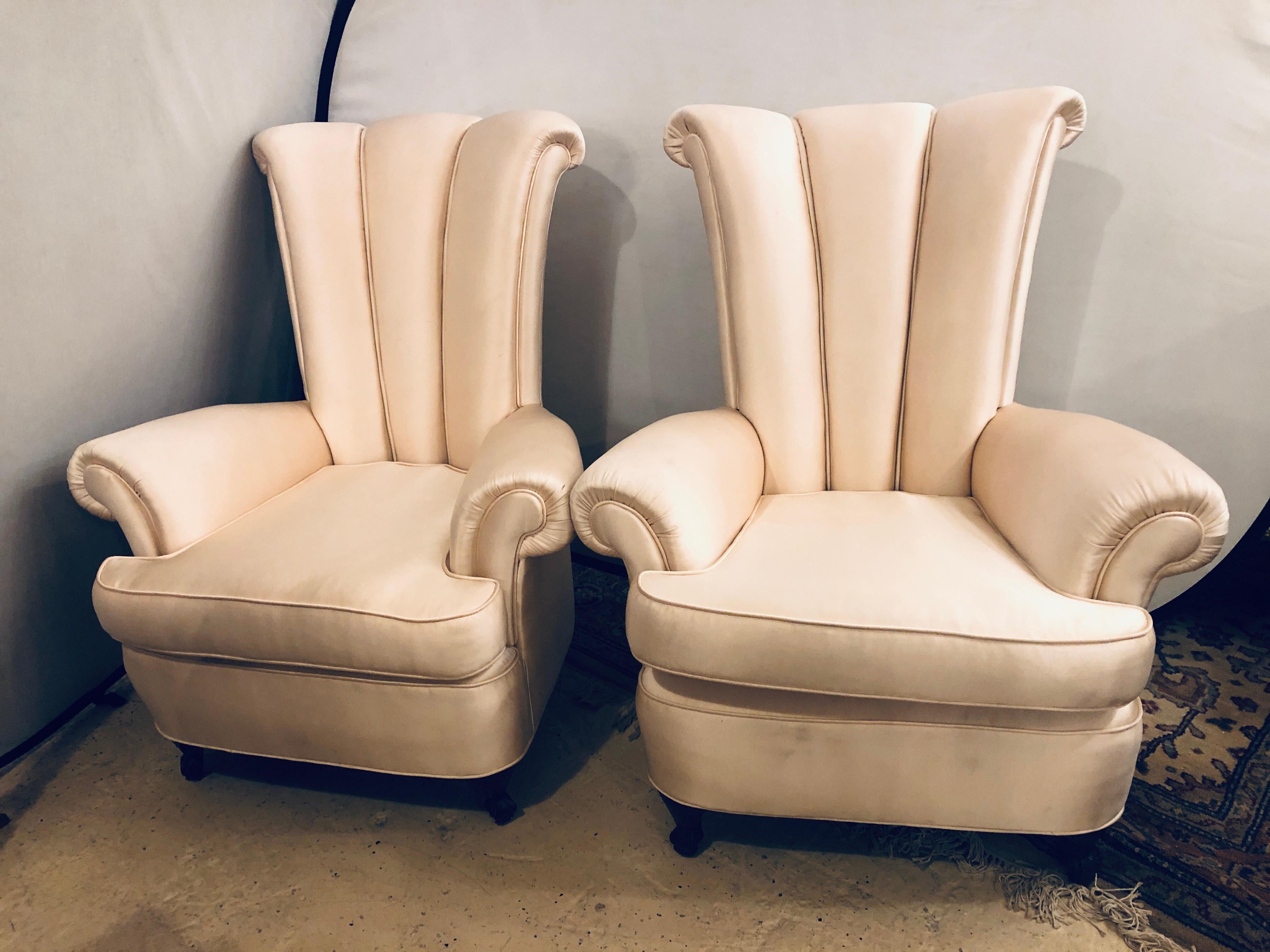 Pair of Hollywood Regency style channel high back chairs each supported by a mahogany short leg. Sleek and Stylish are these finely upholstered armchairs in a linen or silk upholstery. Chair upholstery needs a good cleaning. 