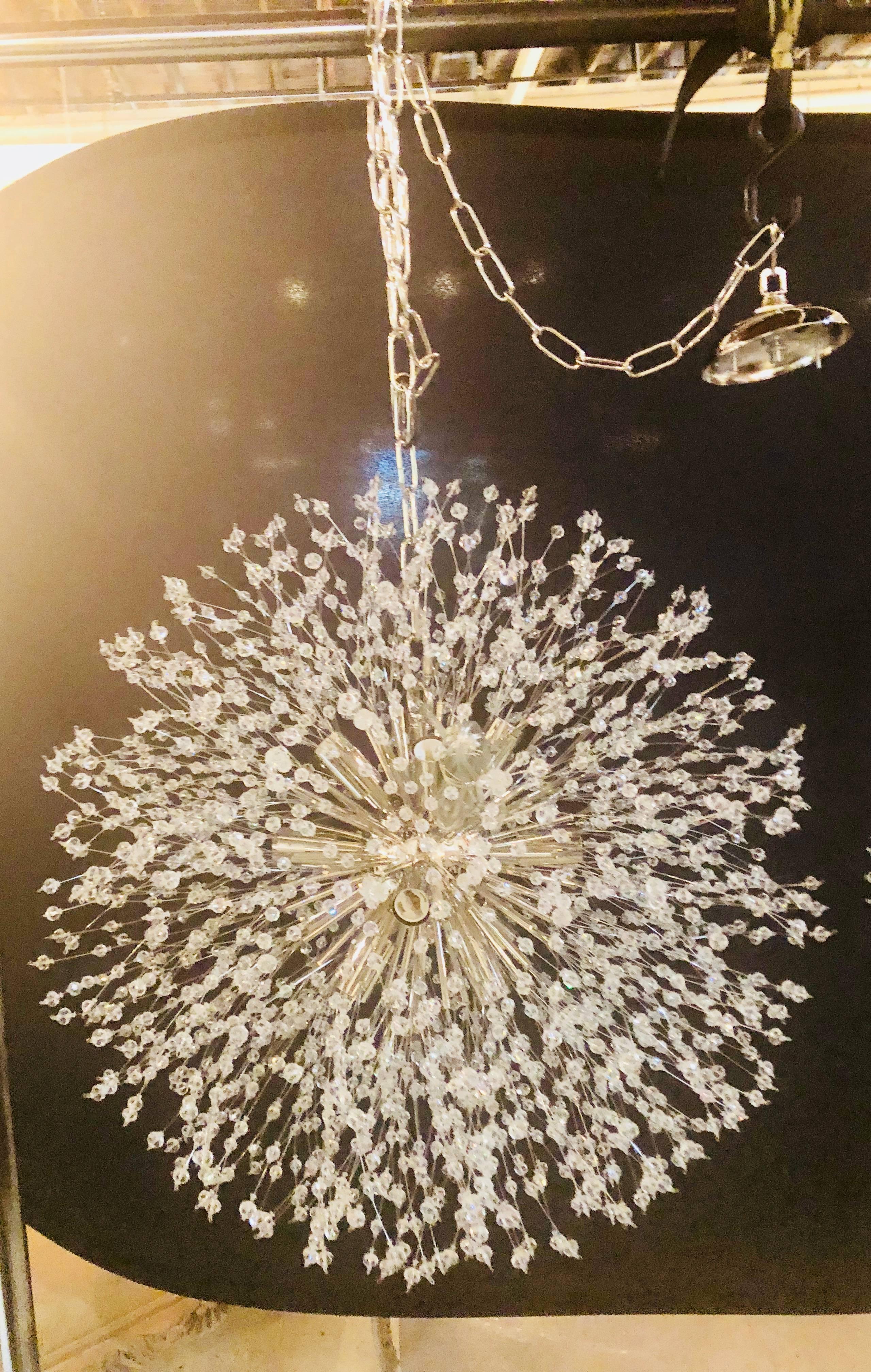 Pair of Hollywood Regency style circular chrome and crystal Sputnik chandeliers. Each having a 40 inch chain and canopy. These wonderfully fashioned chandeliers are sure to light up any room in the home or office having stylish flair as they scream