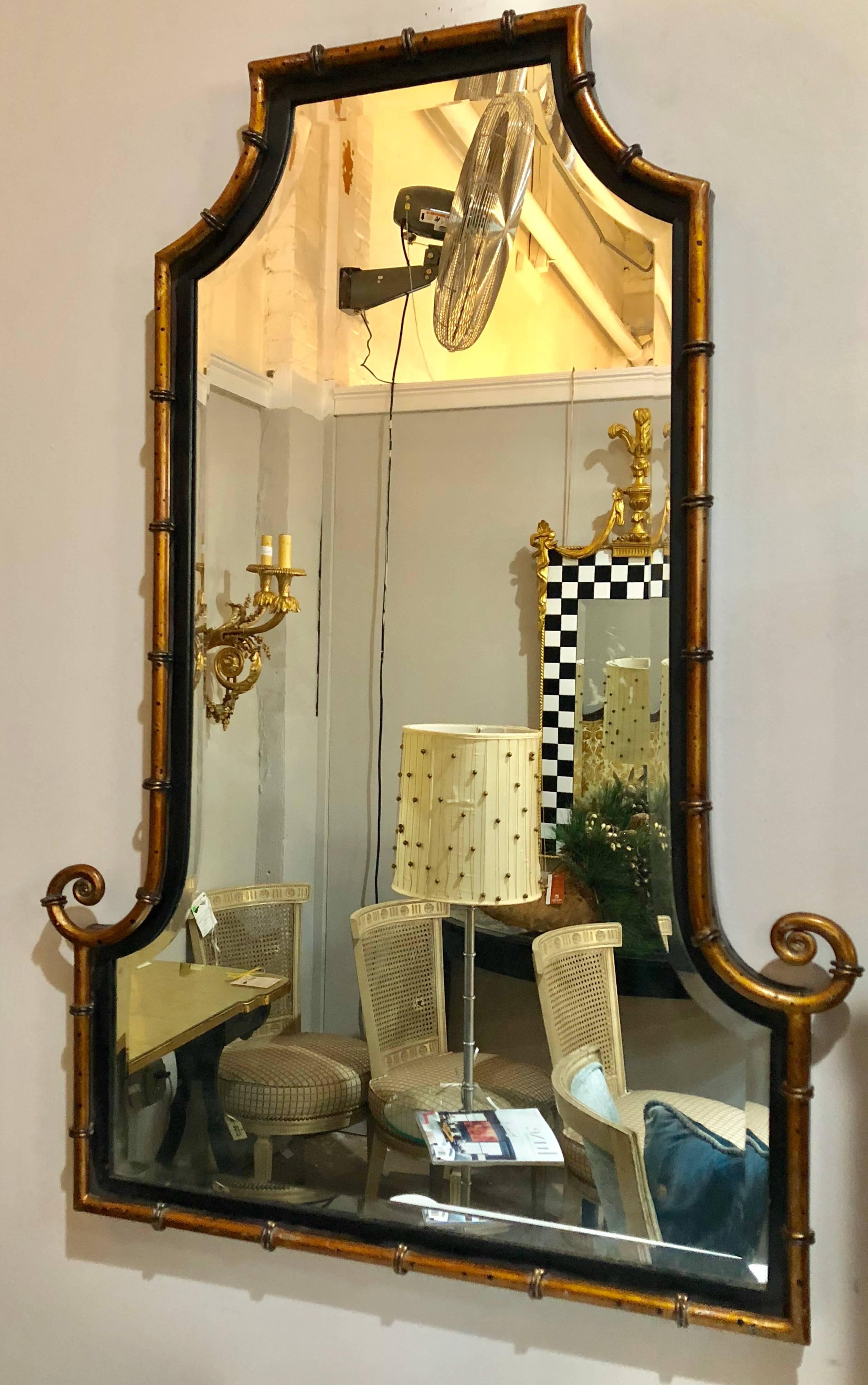 A pair of faux bamboo decorator wall mirrors. Metal bamboo frames on wood base with beveled mirror. Gilt gold highlights with fine ebony finish.
Dimensions: H 41.25 inches, W 28.5 inches, D 2 inches.