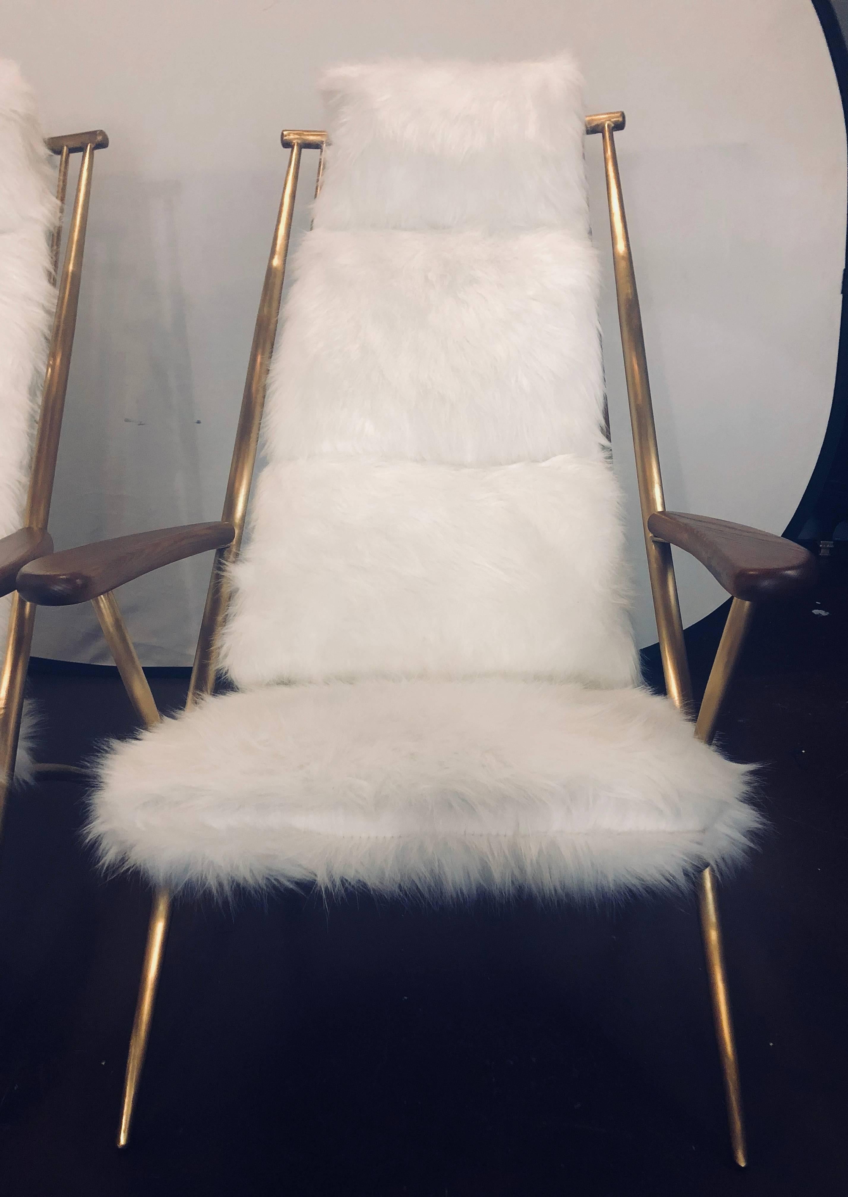 Paire de chaises longues en shearling de style Hollywood Regency, chacune avec un ottoman assorti. La paire est en métal doré, solide et robuste, avec une forme en échelle et des coussins surchargés qui sont étonnamment confortables. Cette paire de
