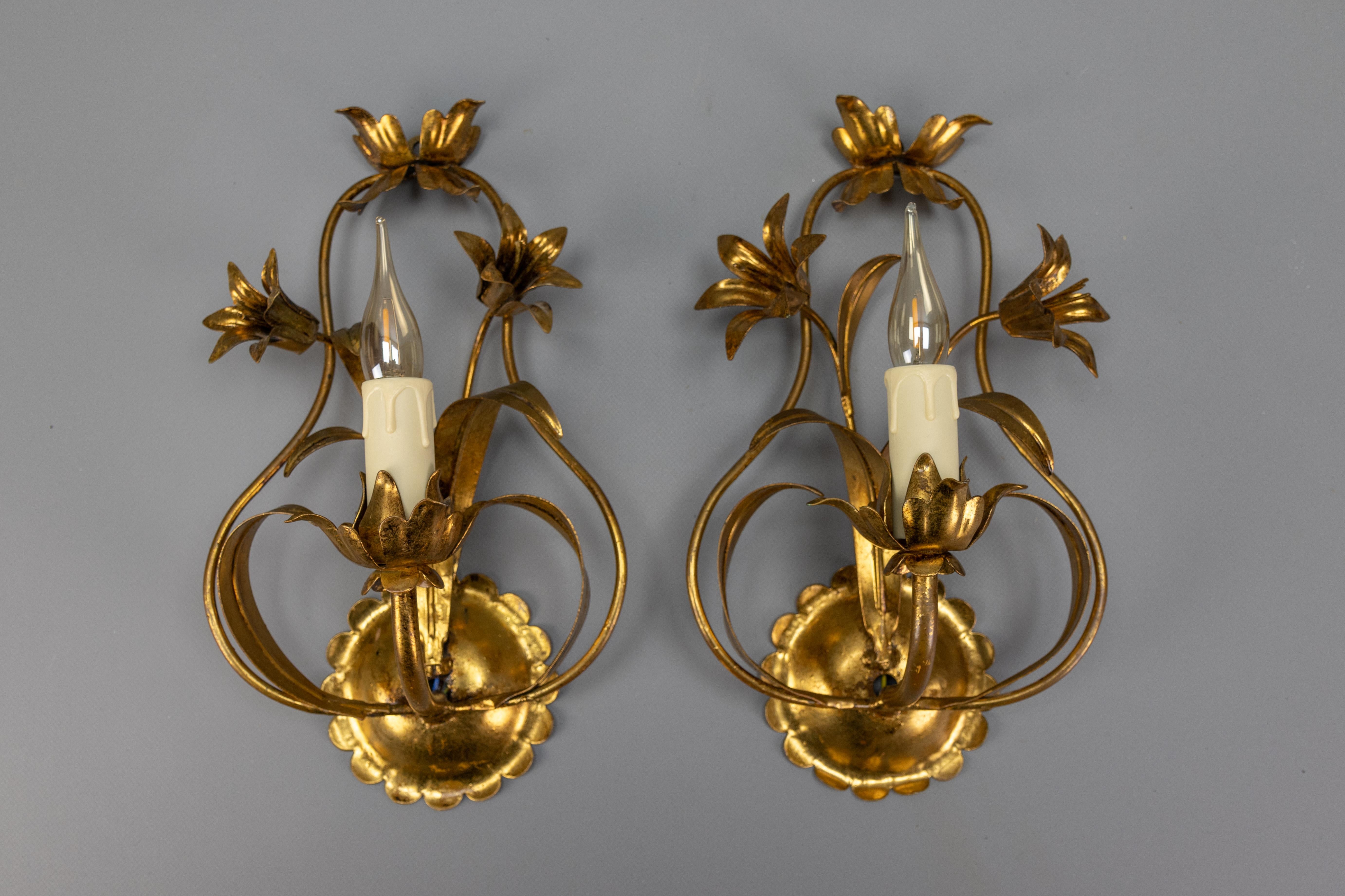 Coppia di gigli da parete in metallo dorato in stile Hollywood Regency, Germania, anni '70 circa.
Questa adorabile coppia di applique in stile Hollywood Regency degli anni '70 presenta un bellissimo disegno floreale realizzato in metallo dorato.