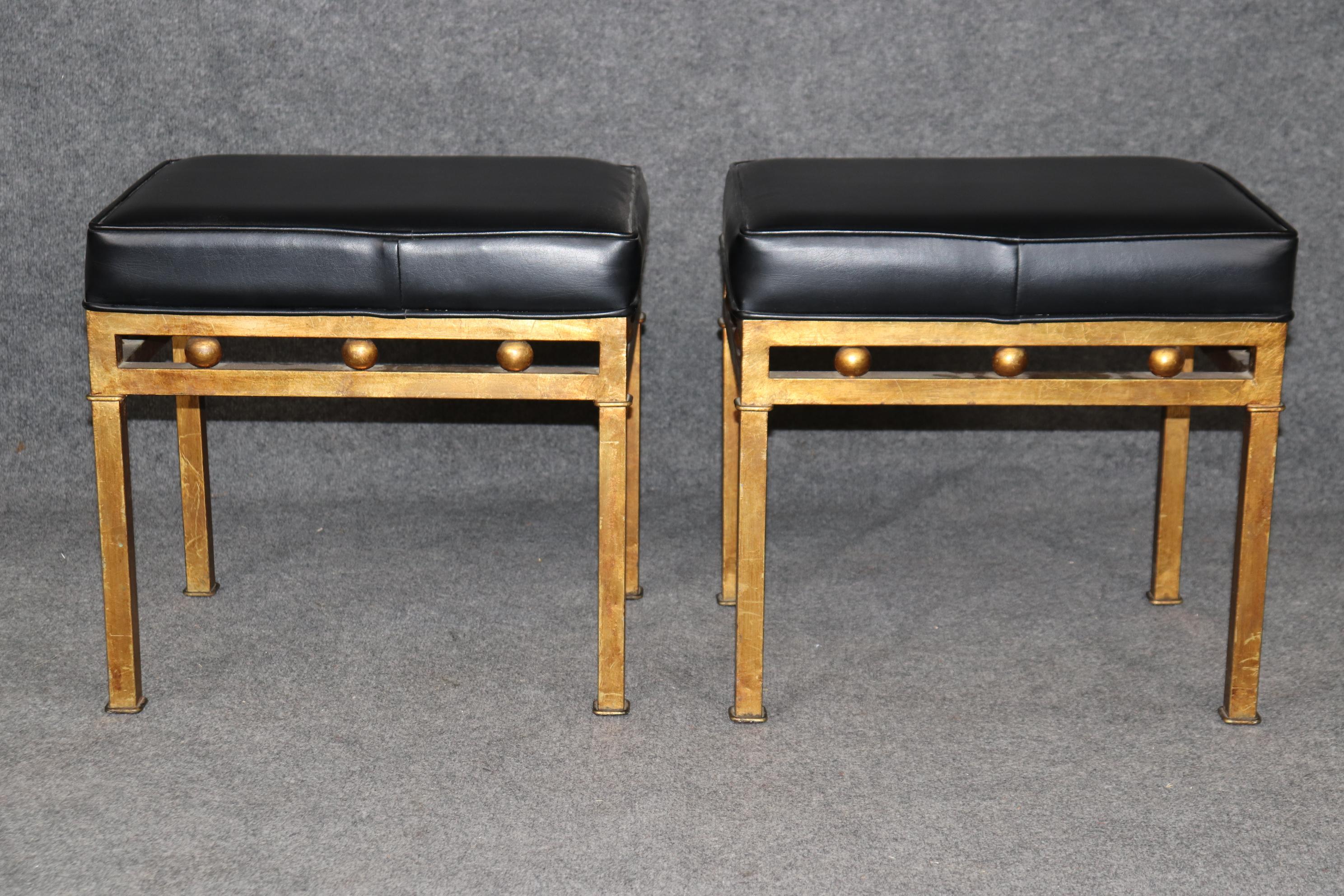 Si tratta di una spettacolare coppia di sgabelli Hollywood Regency con foglia d'oro 23 kt dalle linee semplici e sfere dorate. Gli sgabelli sono in buone condizioni e sono rivestiti in pelle o similpelle. È difficile dire quale, perché la stoffa è