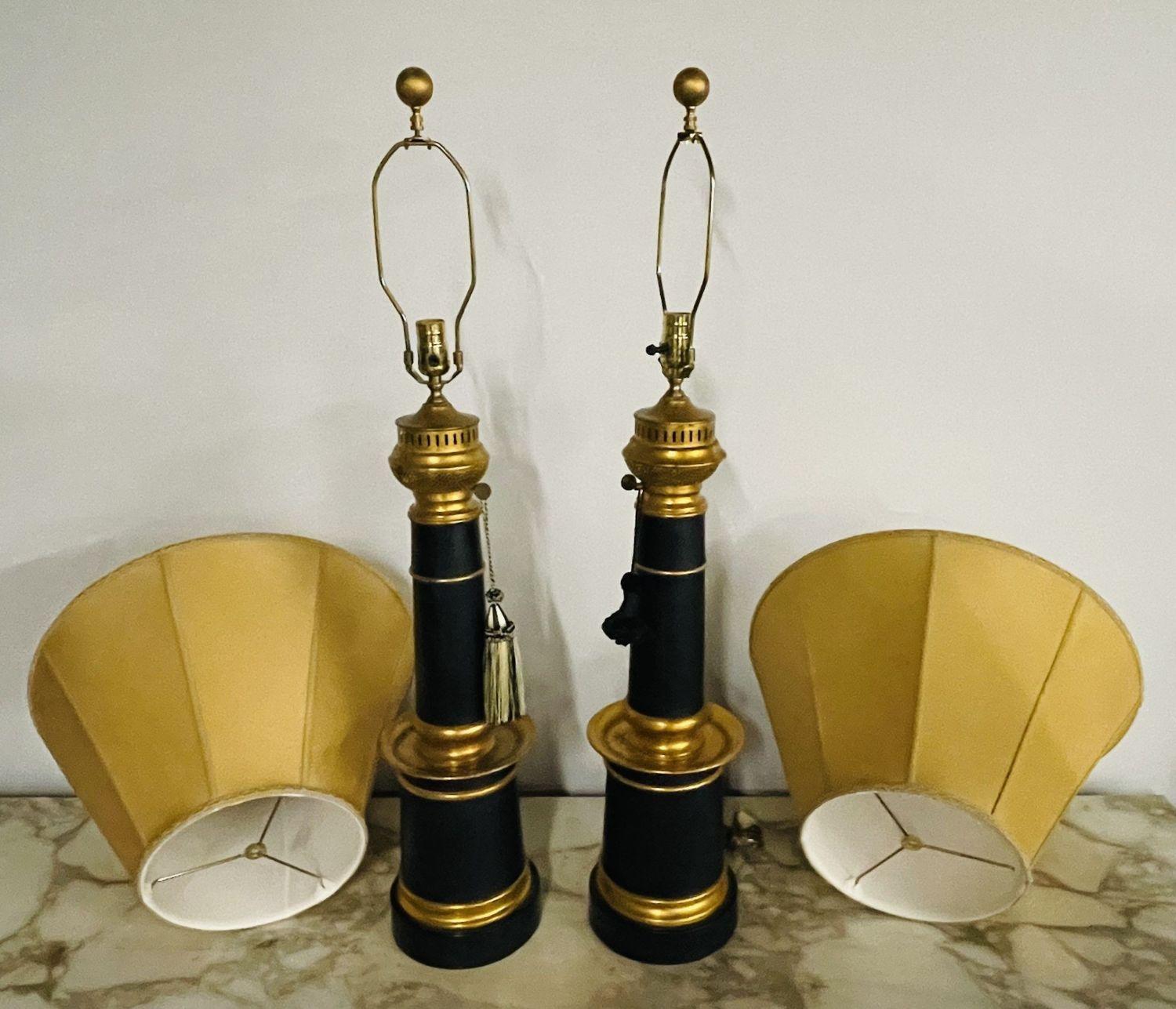 Pair of Hollywood Regency Style Table Lamps with Custom Shades.
 
These stunning Ebony and Gilt metal table lamps are sleek and stylish having the appearance of antique oil lamps. This large and impressive pair have finely detailed custom lamp