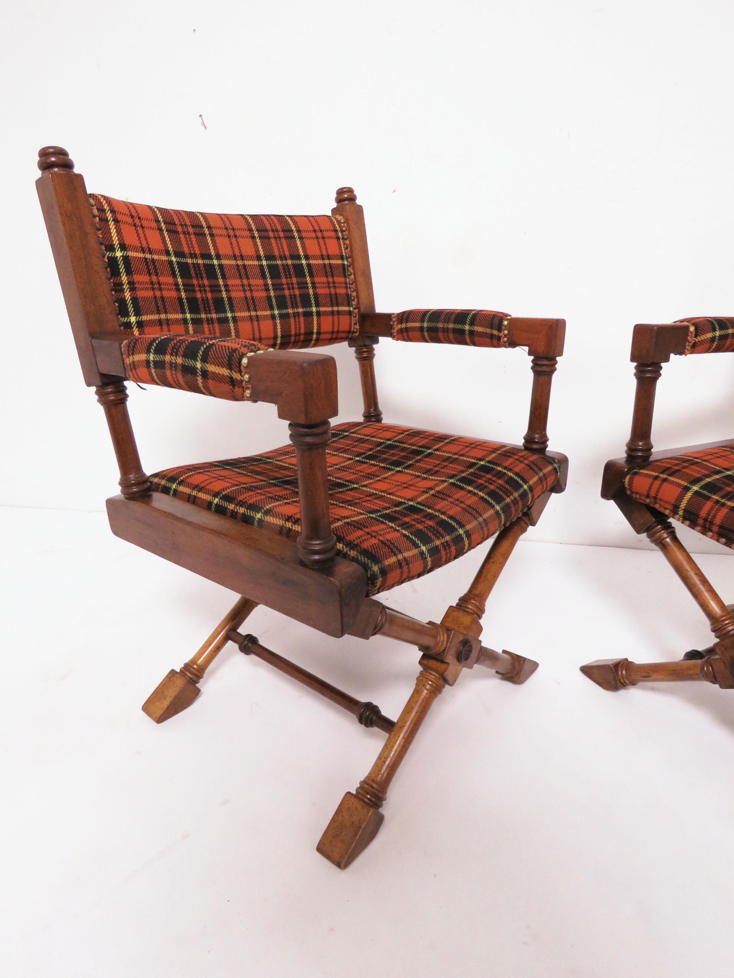 A matched pair of Hollywood Regency style X-base campaign chairs in walnut, circa 1960s. Original Scottish tartan upholstery is remarkably well preserved.