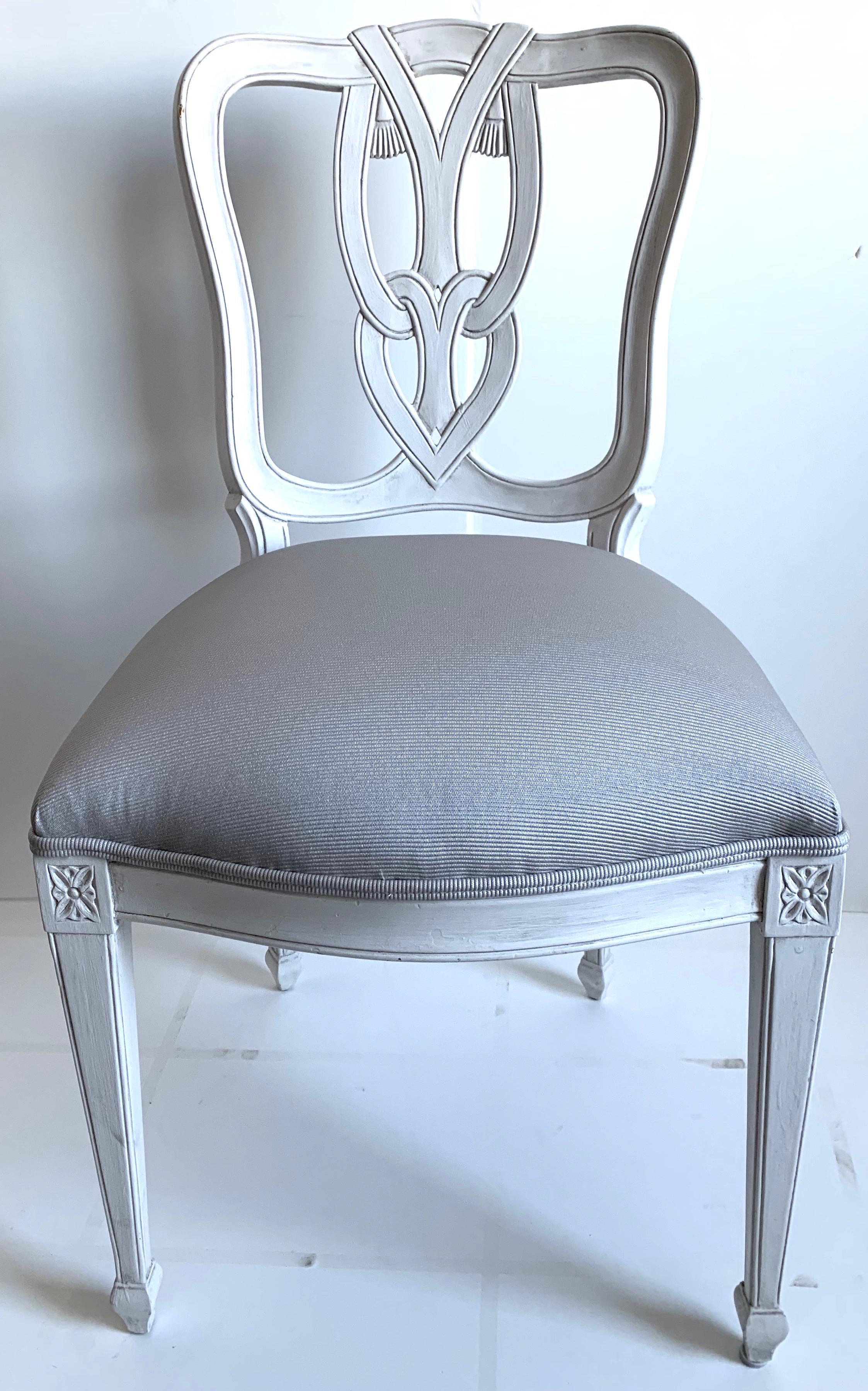 Pair of Hollywood Regency style side chairs. Newly repainted in antique white painted finish. Newly upholstered in Schumacher woven fabric in light gray. Measures: Seat 18