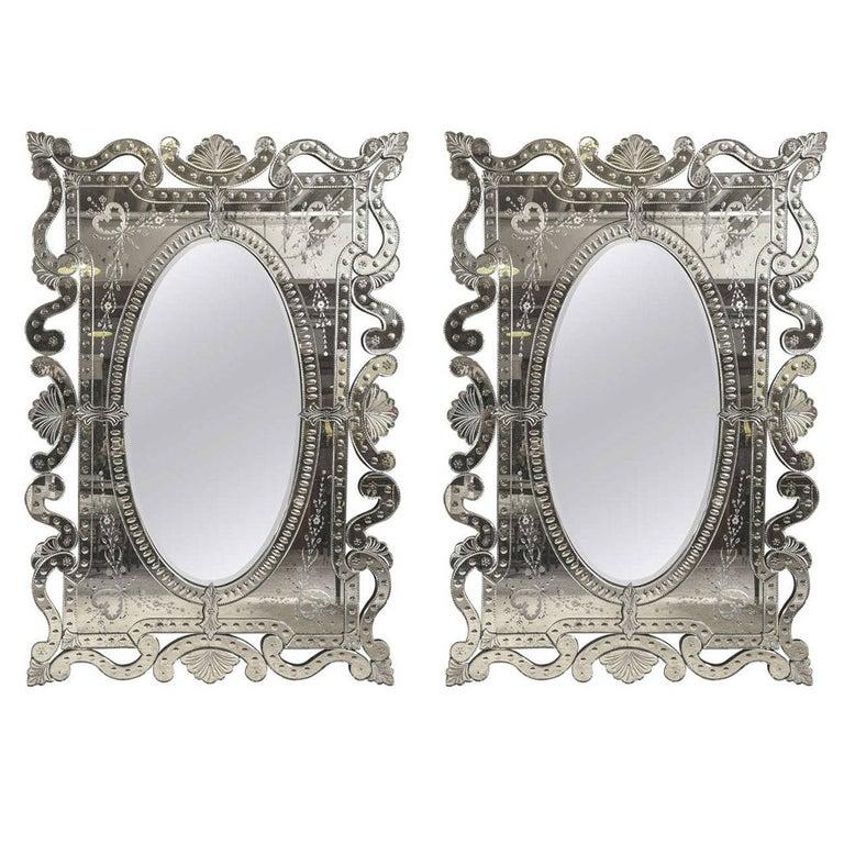 Hollywood Regency style pair of monumental hand etched and cut glass mirrors. These are simply the most impressive of wall or console mirrors. Large in size with finely cut single multiple pieces all formed together to make on impressive