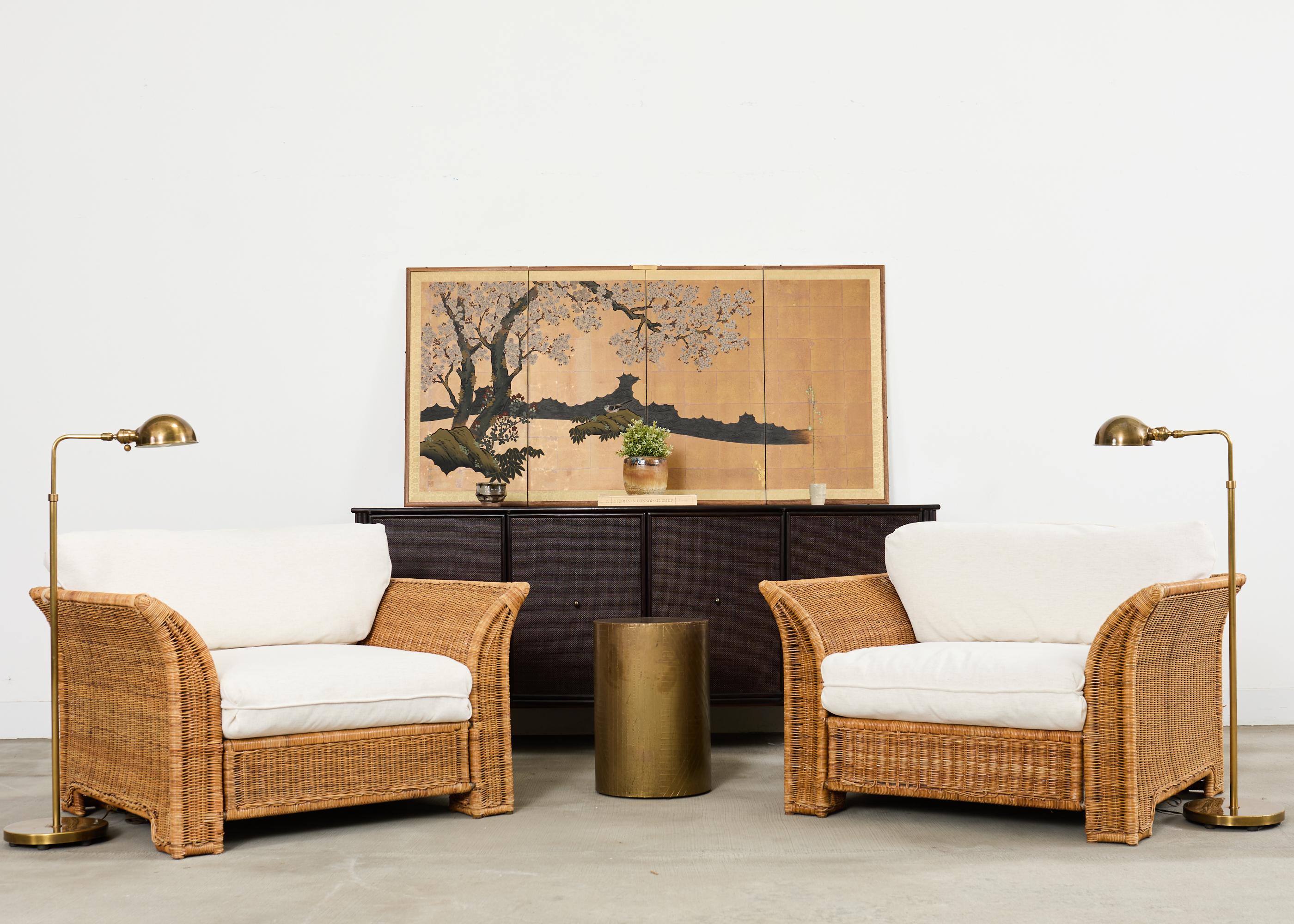 Spectacular pair of large wicker lounge chairs with two ottomans featuring newly upholstered fabric cushions in a soft linen style fabric in beige. The lounge chairs are constructed from a metal frame having a flared cube form covered with woven