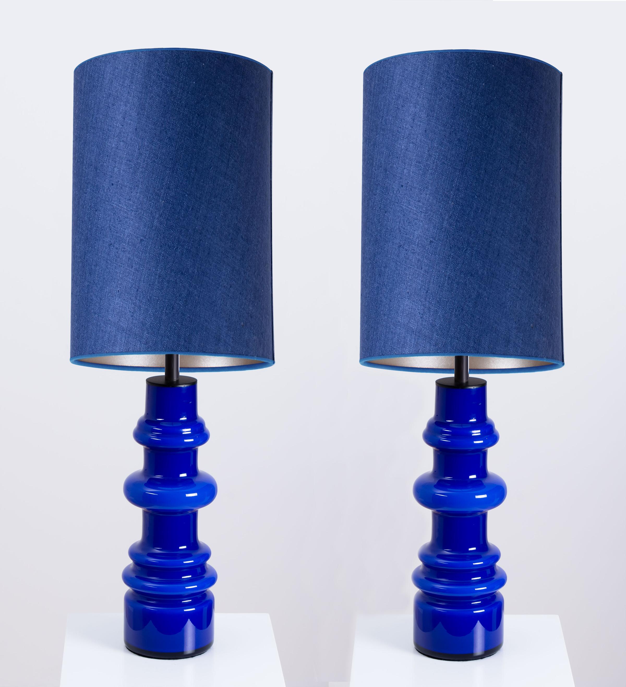 Schönes Paar Tischlampen aus Glas von Holmegaard, Dänemark, 1960er Jahre. Skulpturale Stücke aus handgefertigter Keramik in persischen Blautönen. Mit neuen, speziell angefertigten blauen Seidenlampenschirmen mit warmem gold/silbernen Innenschirm von
