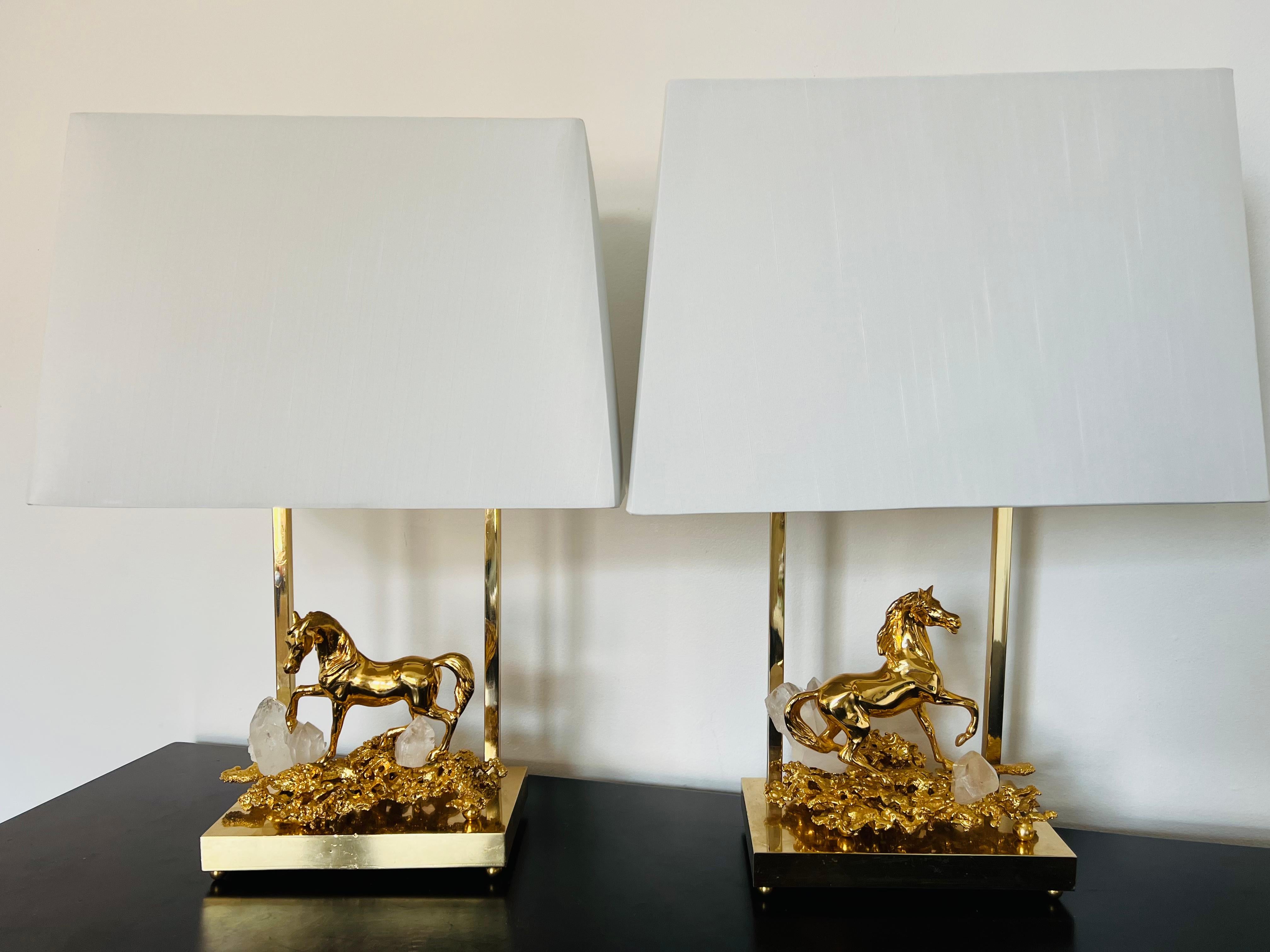 A luxurious gold dore bronze and rock crystal horse table lamps. The gold bronze sculptures are on polished brass bases and they have complimentary linen shades. Rewired with gold silk cords and solid brass sockets. Signed.