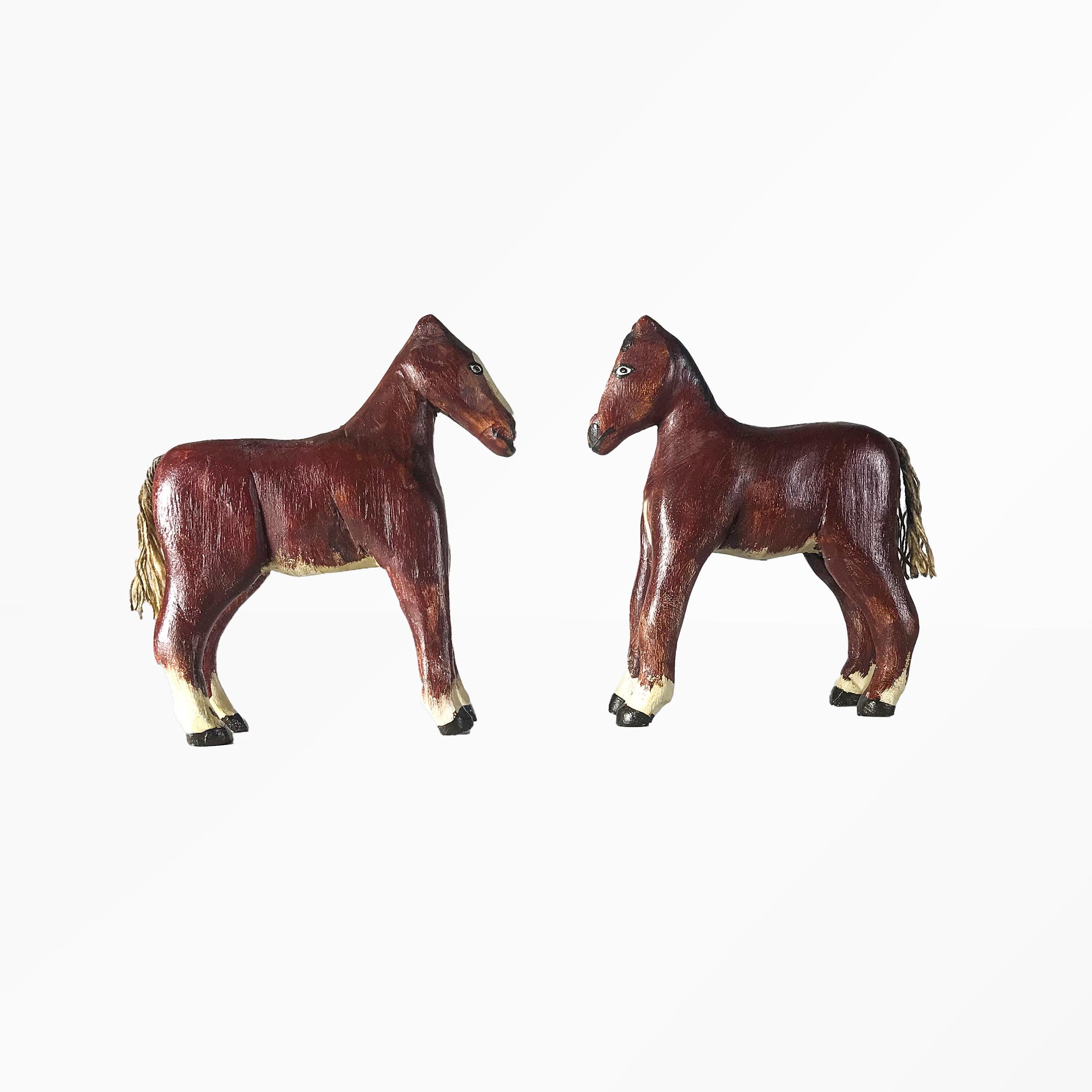 Carved horse toys in standing position, painted in a crimson brown color with painted eyes and painted mane on one side of each horse. Painted patches of white along the nose, chest, belly and ankles, with threaded tails
American, circa 1940-1950,
