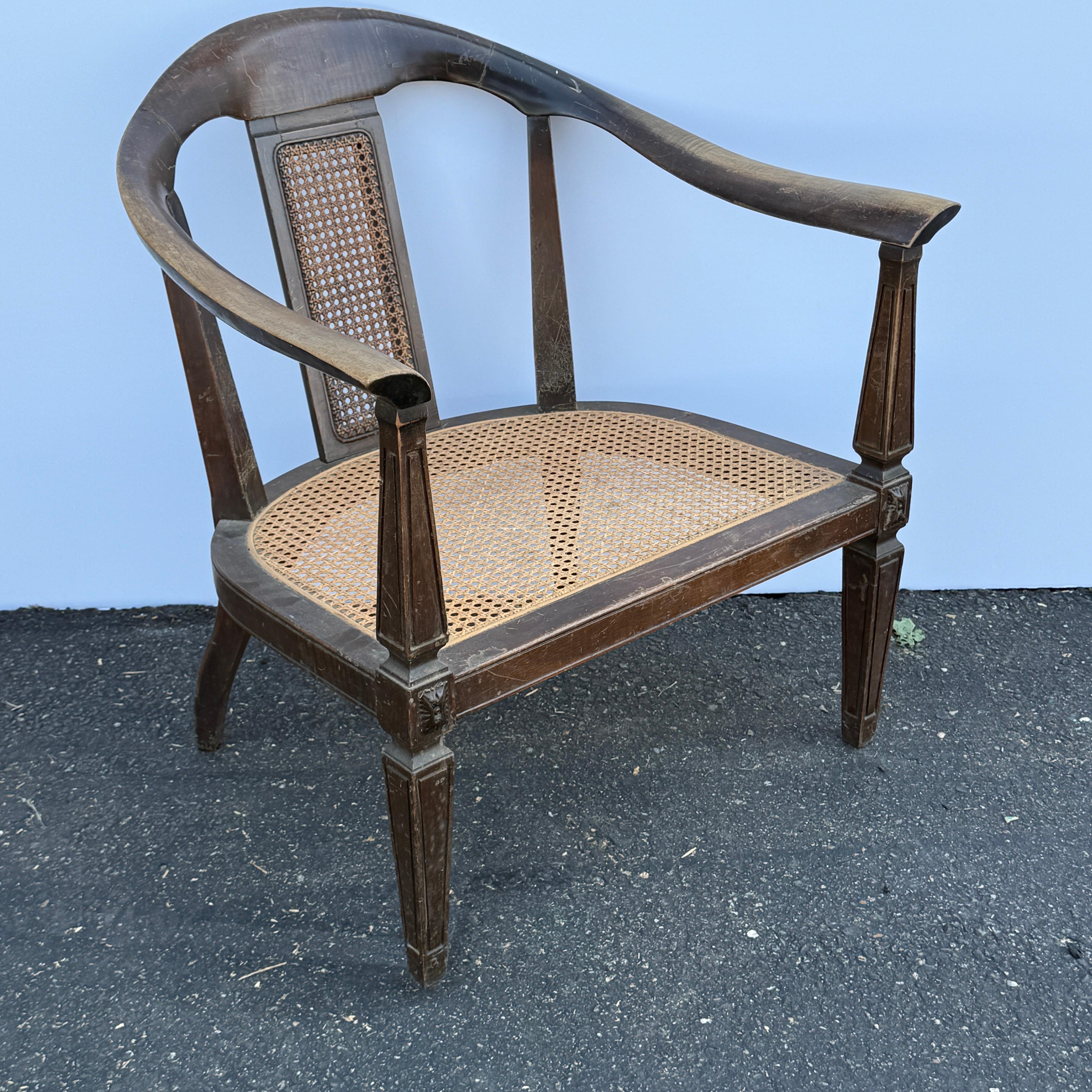 This pair of elegant American Mid-Century armchairs feature hand-carved wooden frames with graceful curves. The cane seats add an air of lightness. The generously wide proportions make it particularly inviting and comfortable, offering a relaxed