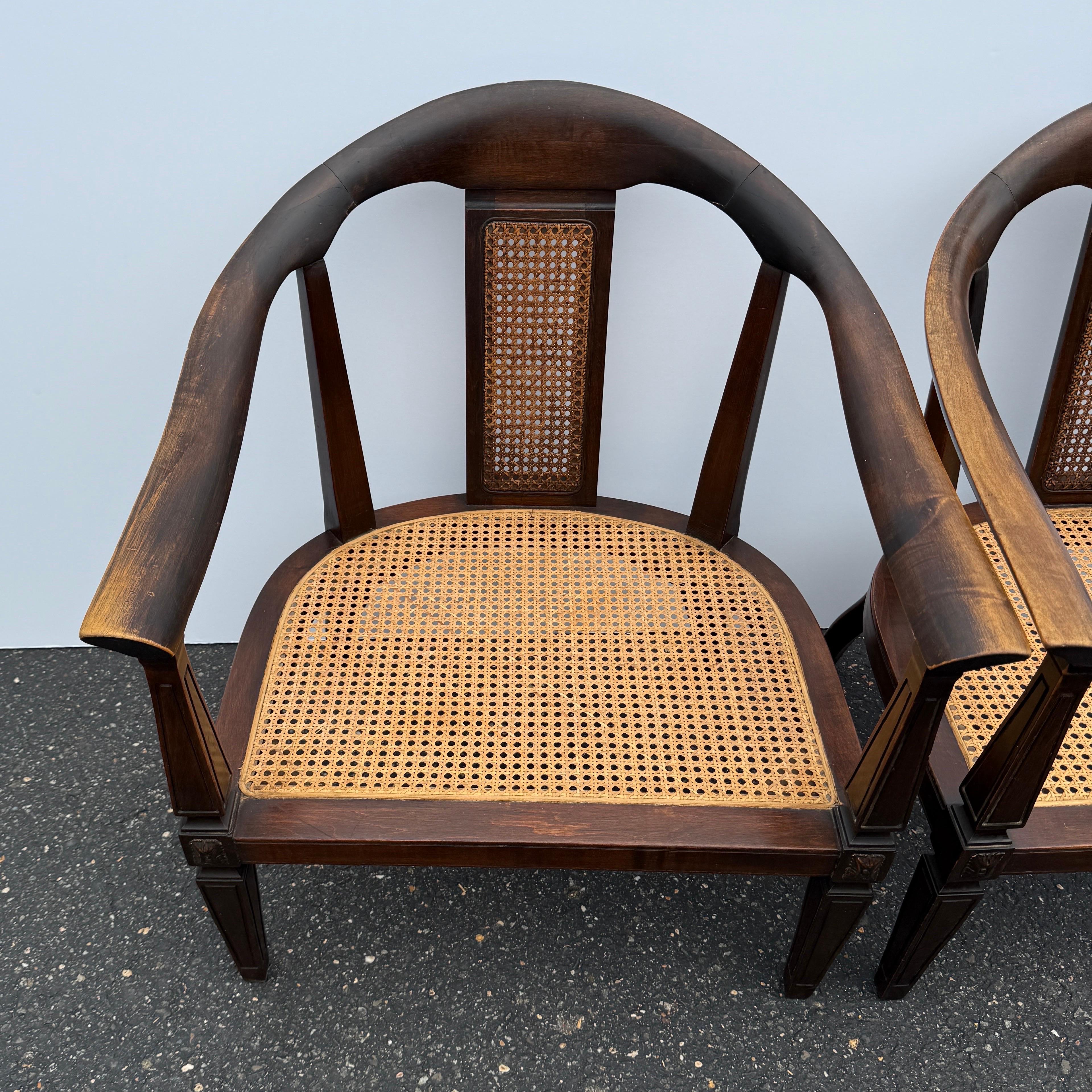 Dieses Paar eleganter amerikanischer Mid-Century-Sessel verfügt über handgeschnitzte Holzrahmen mit anmutigen Kurven. Die Sitze aus Schilfrohr verleihen einen Hauch von Leichtigkeit. Die großzügigen Proportionen machen ihn besonders einladend und