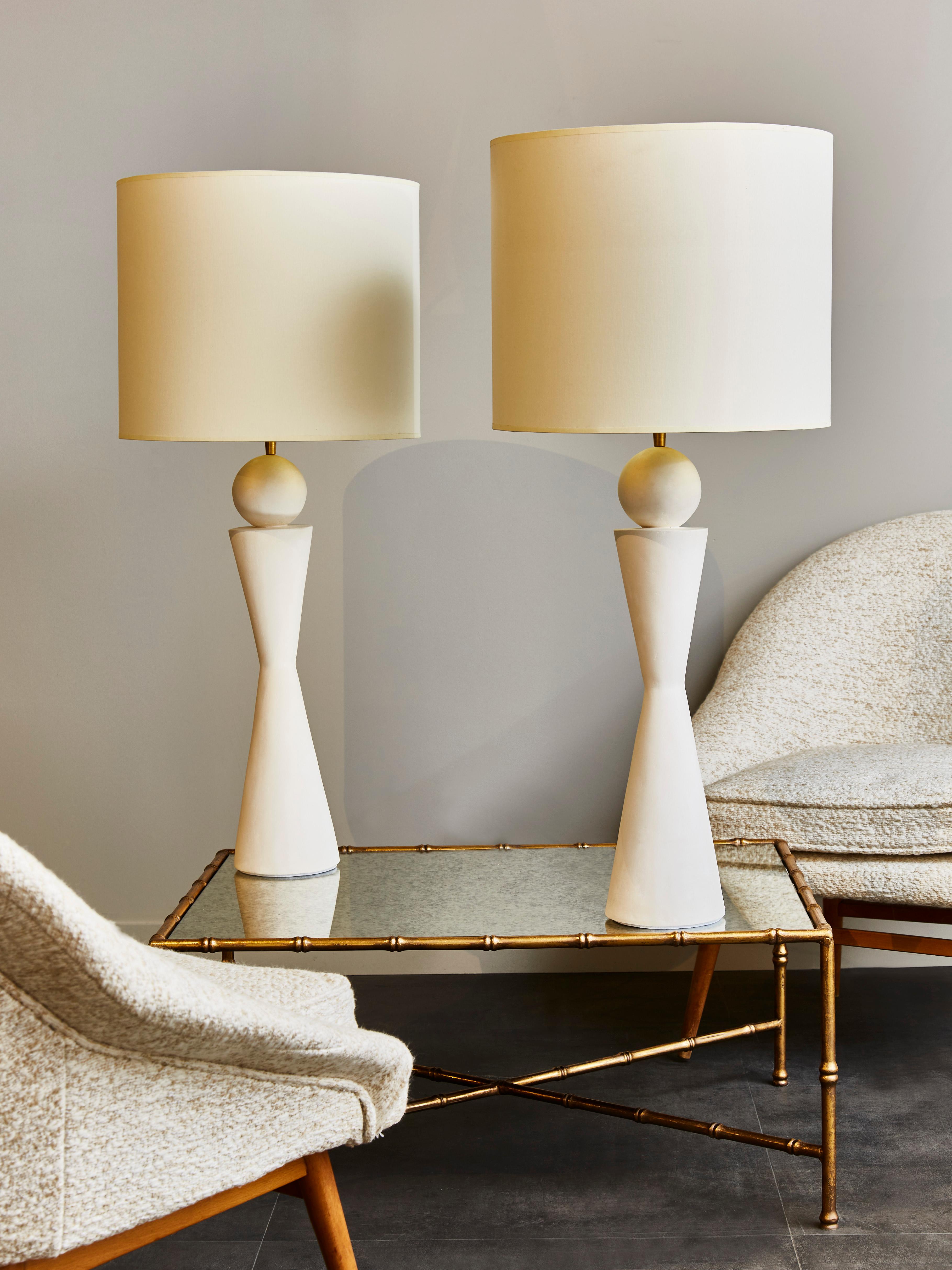 Pair of plaster table lamps in hourglass shape with brass settings.

Contemporary work made in France.
  