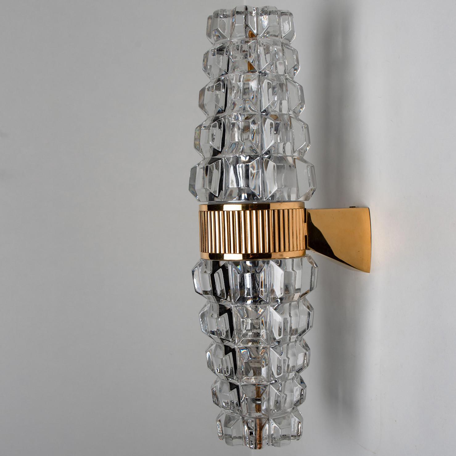 Pair of  High end wall sconces, made in France, Europe, around 1970. The wall lights are made of lead crystal and a brass frame holding the glass.

Dimensions:
Height: 13.78 inch (35 cm)
Width: 3.94 inch (10 cm)
Depth: 5.9 inch (15 cm)
Please notice
