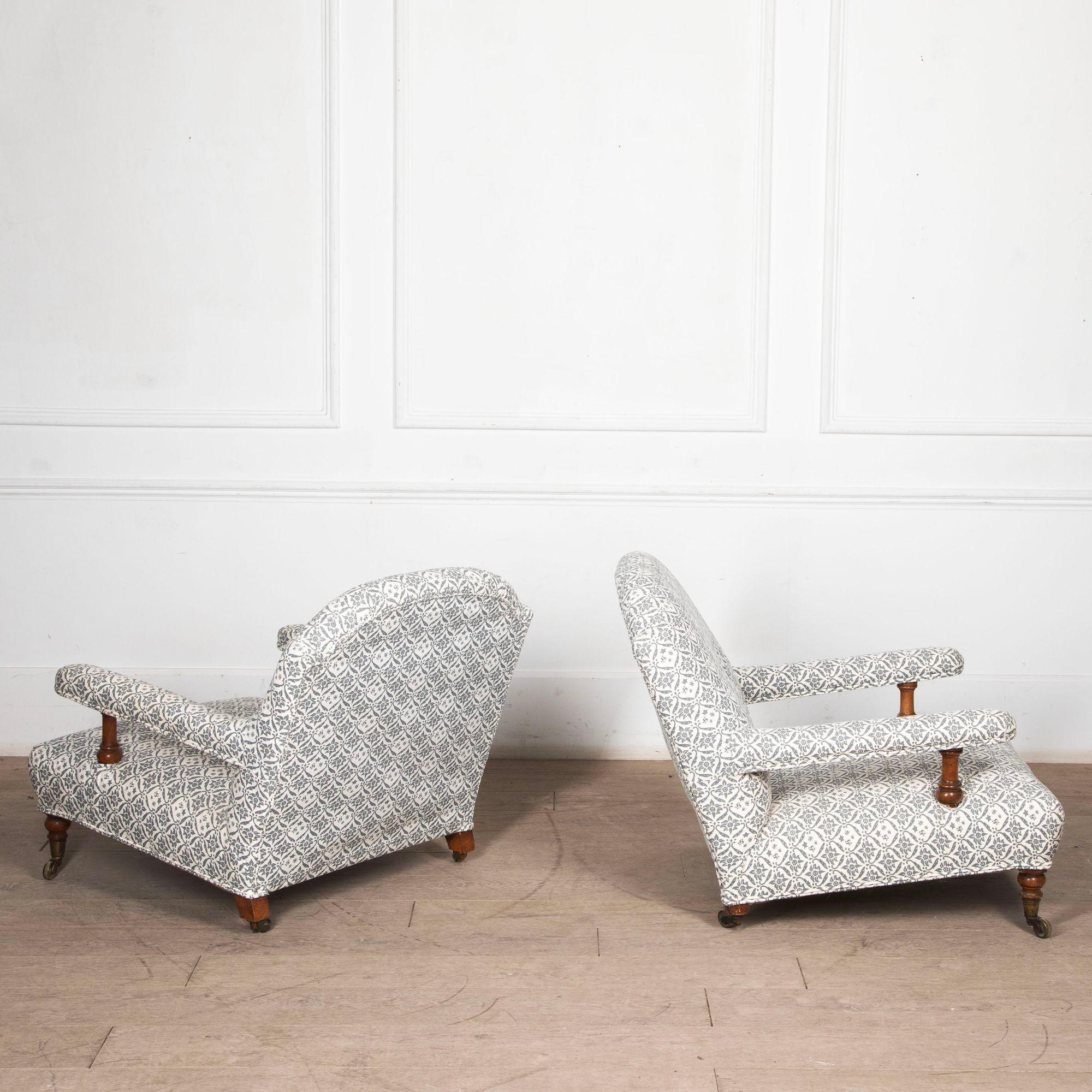Pair of English Howard and sons 'open arm' low armchairs.
Circa 1870 with fine turned front legs upholstered in Howard and sons blue ticking.