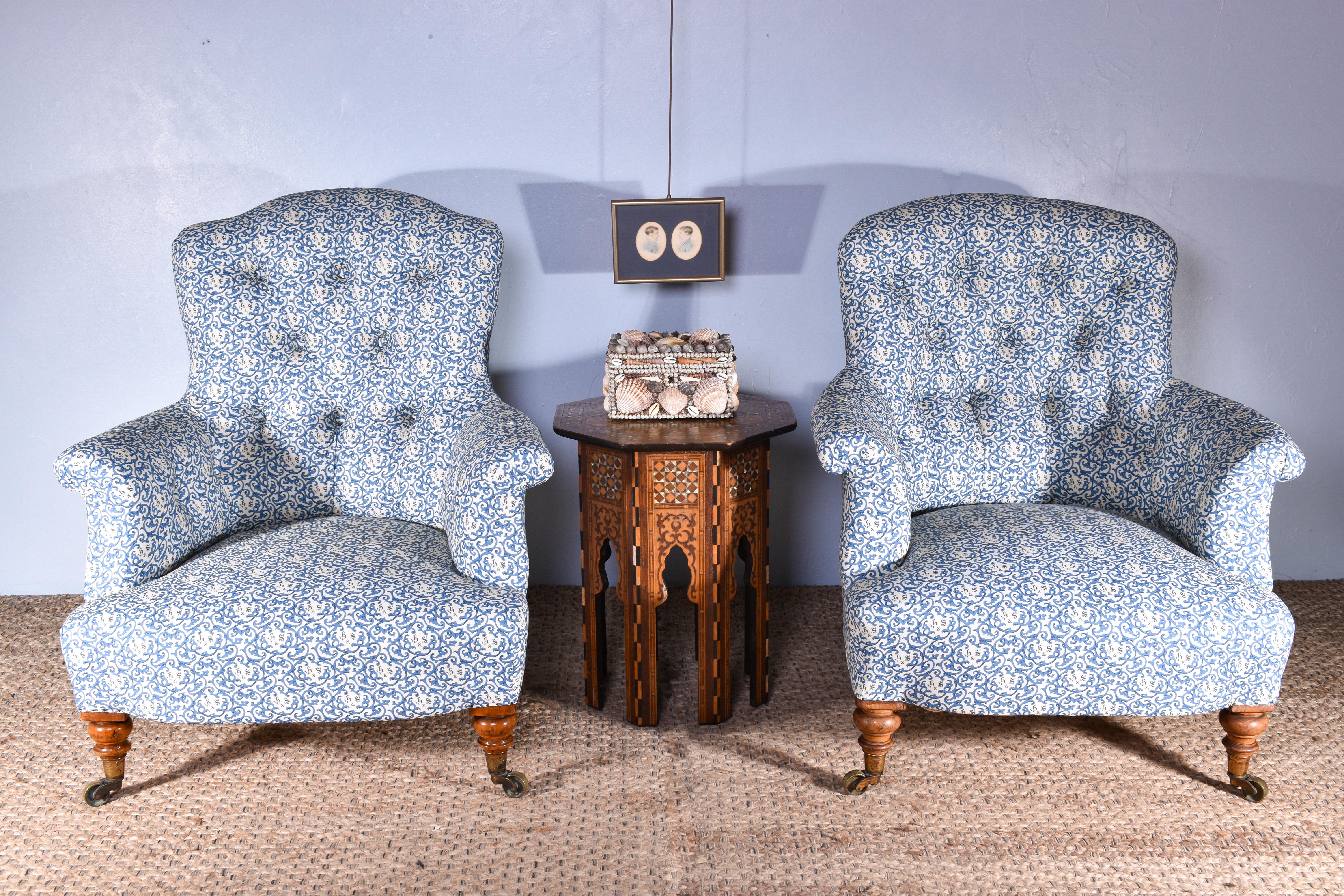 A lovely pair of Howard & Sons armchairs, with deep-buttoned back rests. C.1850

Traditionally upholstered in the earlier Howard and Sons monogram cotton fabric, in blue.

Raised on walnut legs with all original Cope Collinson brass castors, both