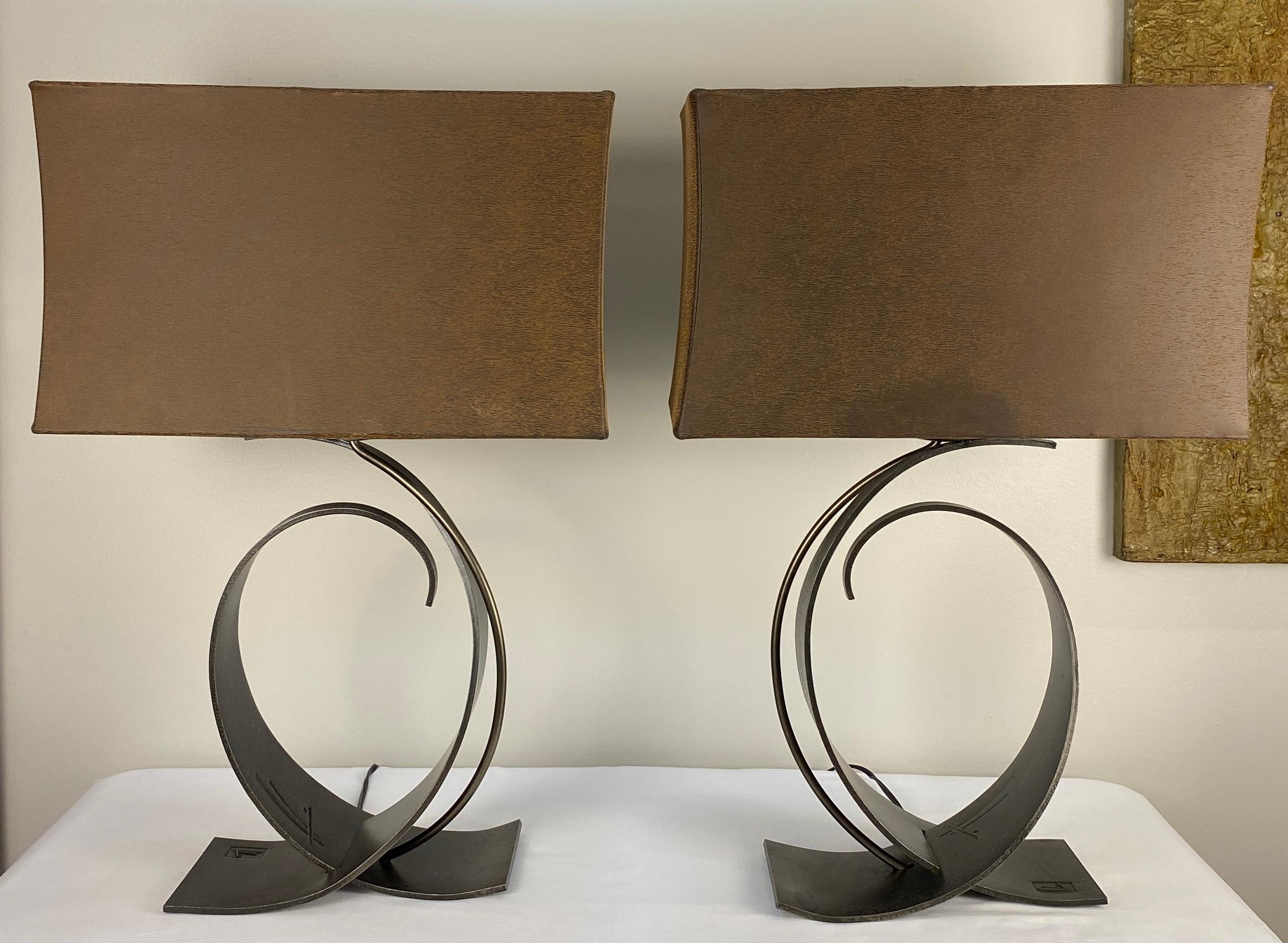 Pair of fine quality forged iron table lamps by Hubbardton. 

Feel the fluidity of Hubbardton, forged by hand in the state of Vermont. Each light fixture is inspired by Art Nouveau designers like Hector Guimard, Antonio Gaudi, and Victor Horta who