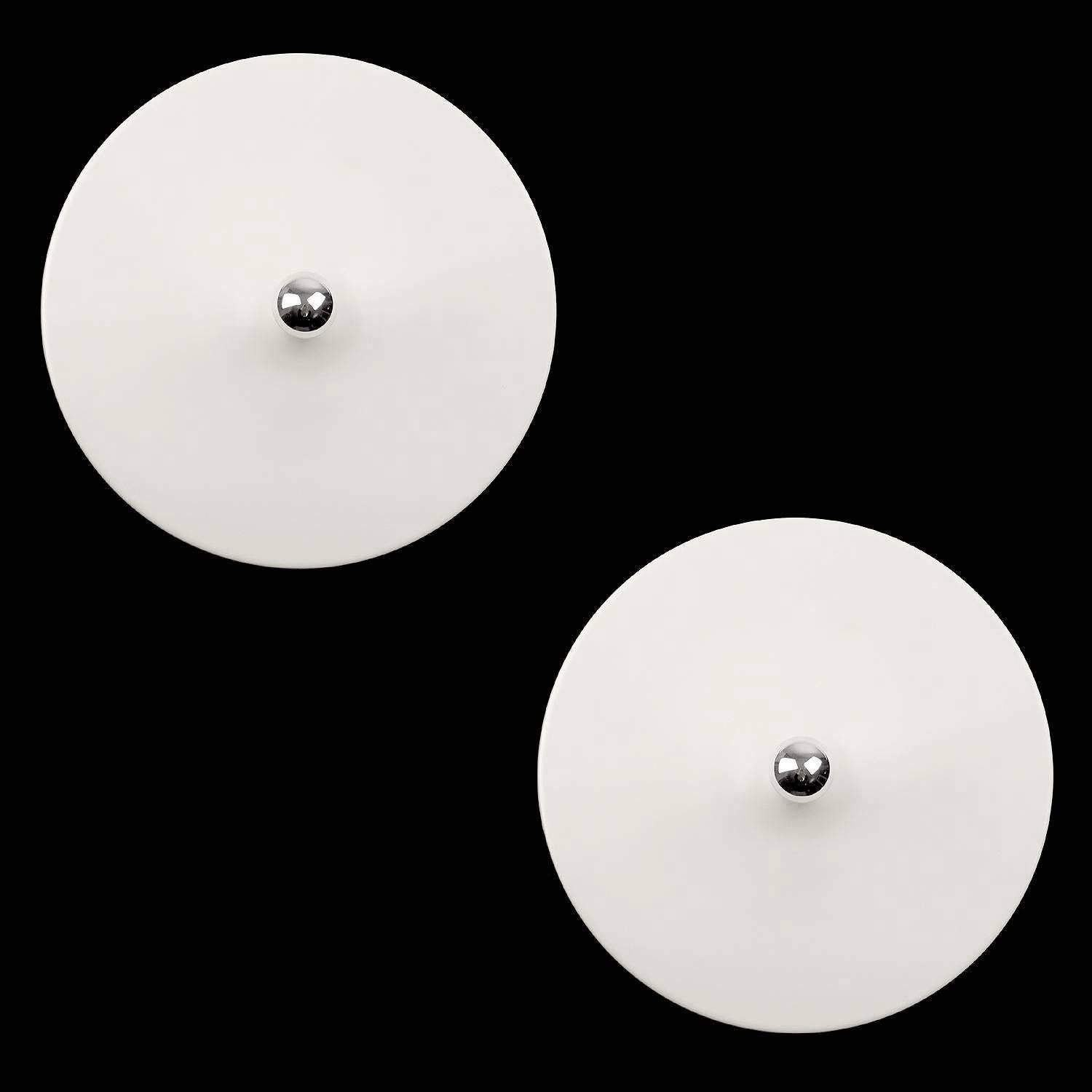 Pair of very large white enameled disc shaped sconces based on a design by Charlotte Perriand. Due to their unusual large size, these sconces will perfect complement grand entrance, bars, hotel lobby restaurant,etc. Rather than excelling in elegance