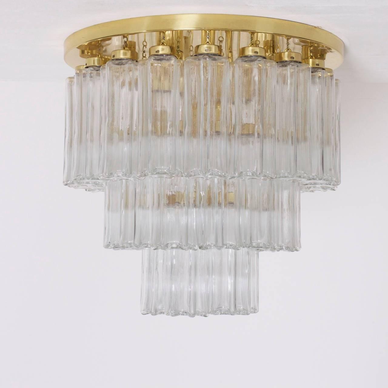 A pair of high quality Limburg chandeliers. This pieces are an example of Limburg's Modernist re-interpreted of the Art Deco tiered chandelier. 

The chandelier consists of a brass plate with 36 hanging clear glass shades arranged in a circular