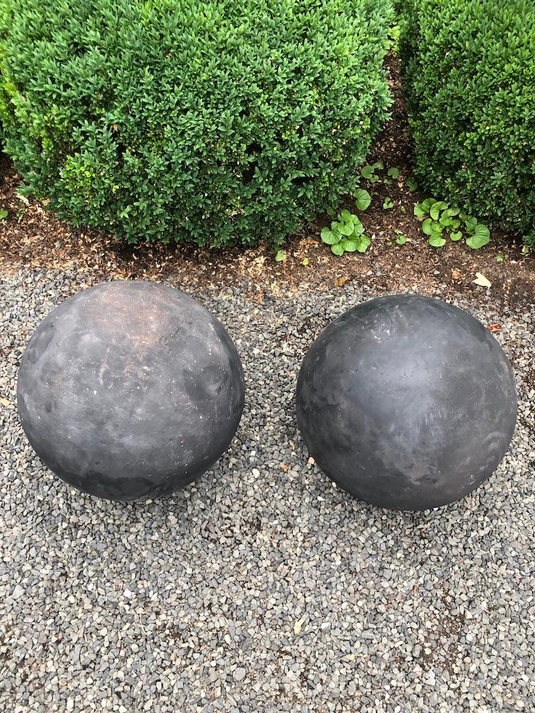 Antique carved stone spheres used to be relatively easy to find, but they have become scarce as hens' teeth over the past 10 years. This is a magnificent and rare pair of very large carved red sandstone spheres that originally each had 3 bent bronze