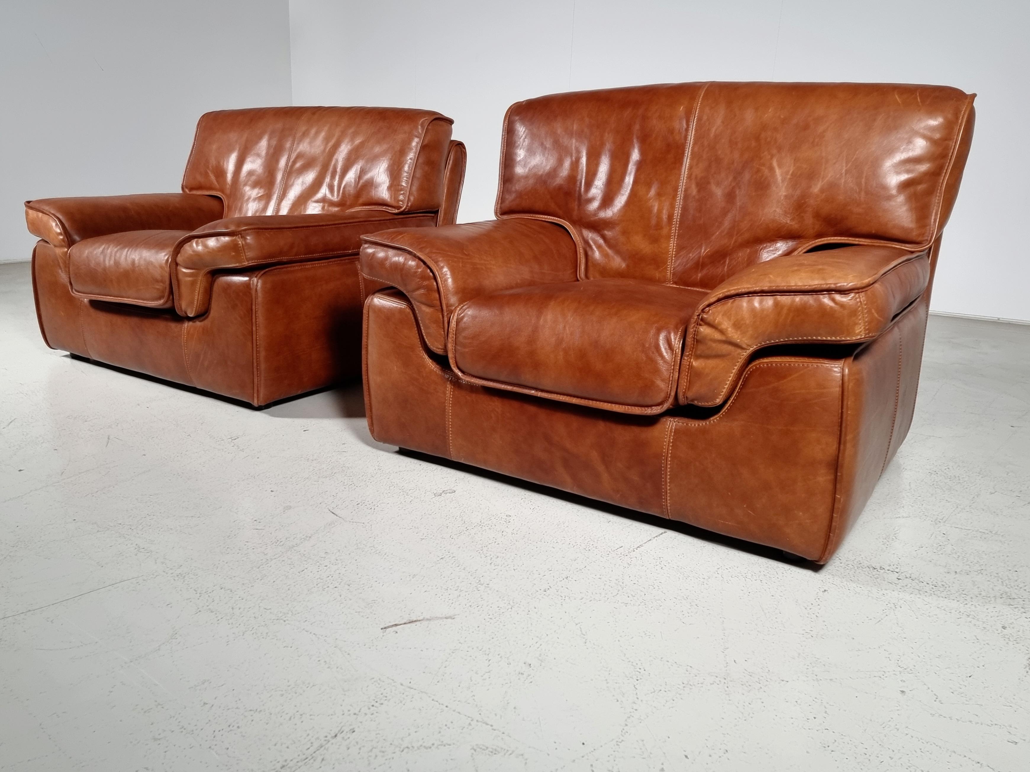 Beautiful set of 2 buffalo leather lounge / easy / club chairs in cognac leather with same color piping’s, Italy, 1970s. Comfortable seat with stunning detailing and great craftsmanship. The leather shows rich and beautiful patina.

