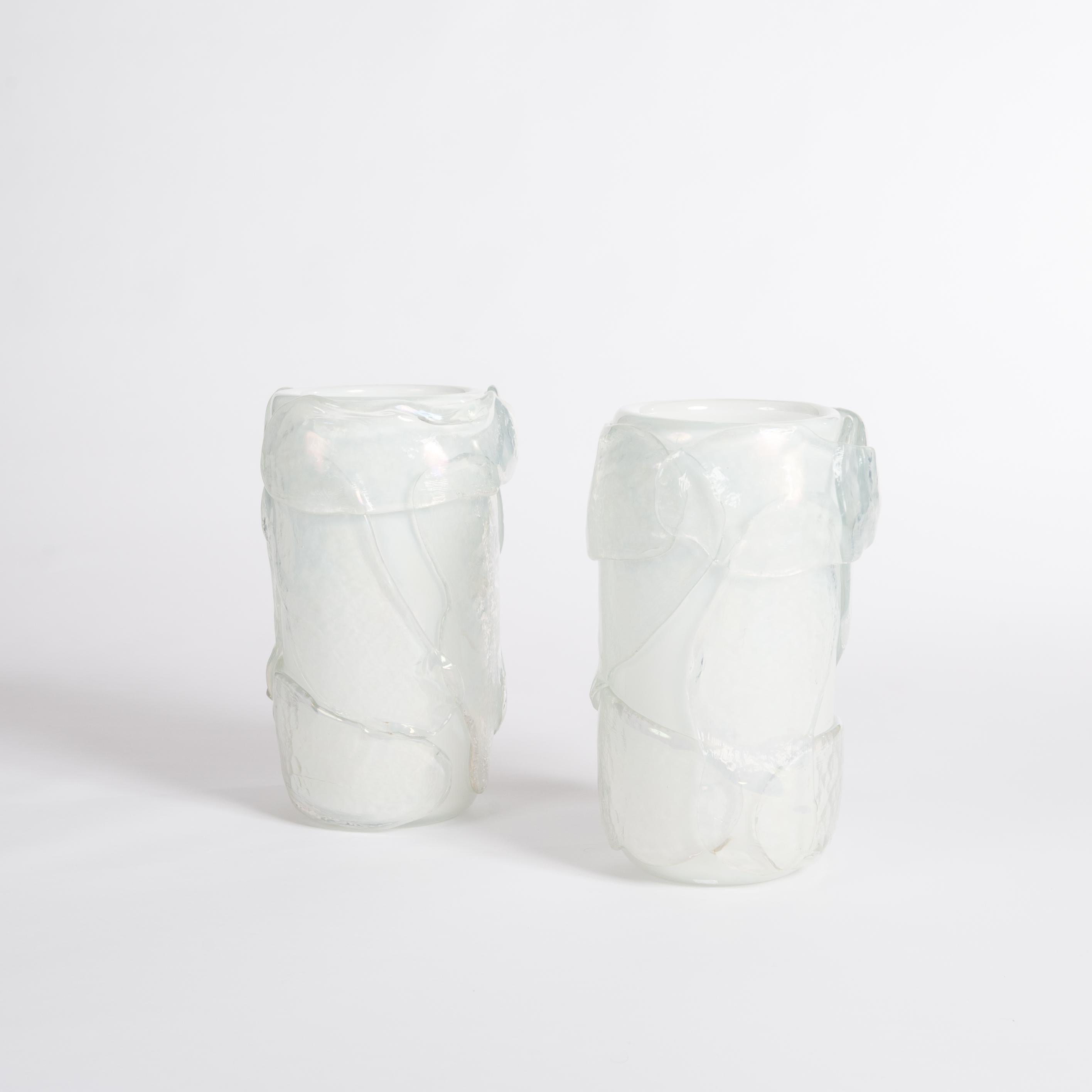 A pair of modern Italian Murano glass vases white-irisdecent colored with surreal impression.
The straight lined body out of white Murano glass shows enormous opal glass leaves outside on the surface and turns the
vase into a sculpture.
The vases