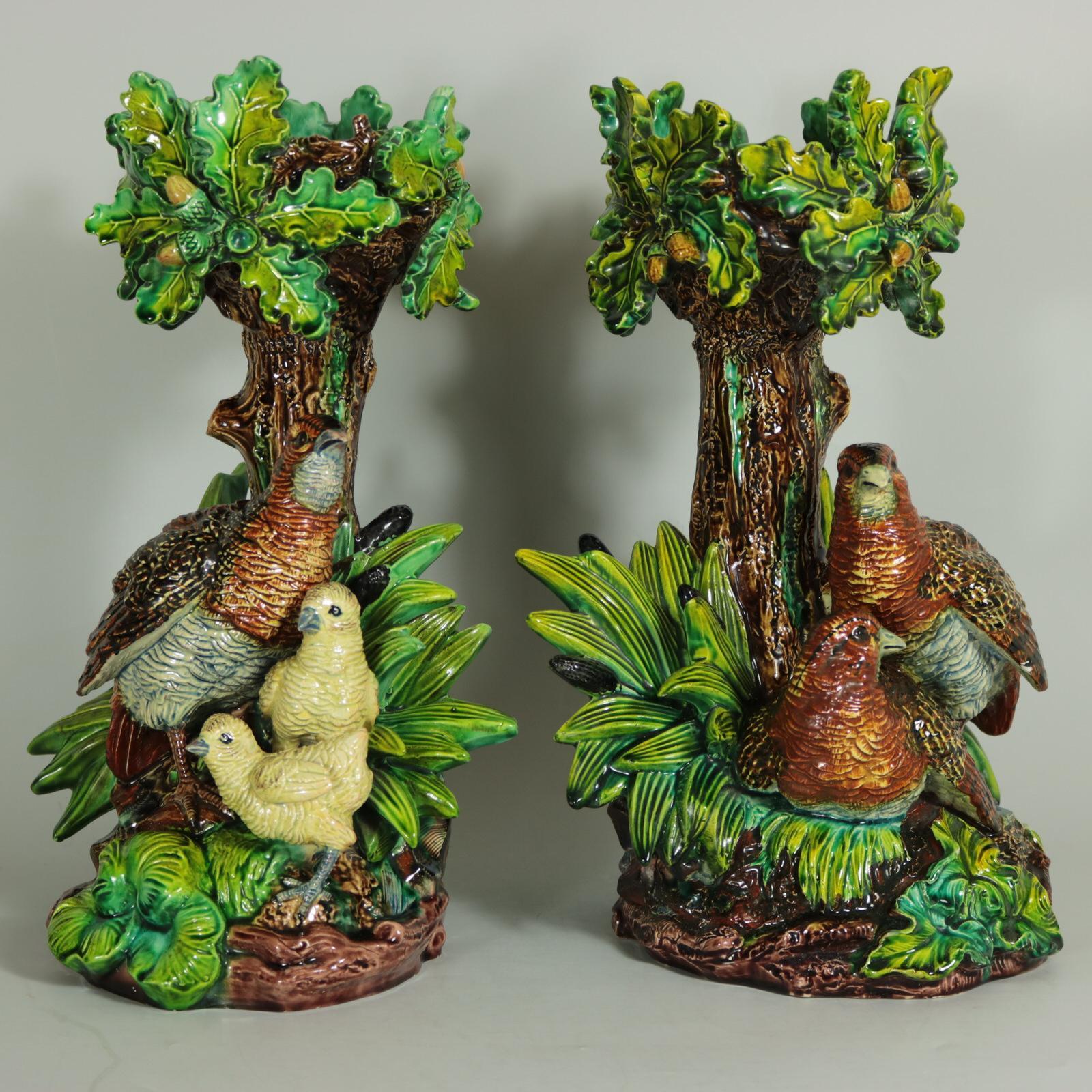 Pair of Lonitz Majolica cache pot stands which feature partridges in front of an oak tree, with reeds and bulrushes (cattails) either side. One partridge is looking after her young chicks. Colouration: green, brown, yellow, are predominant. The