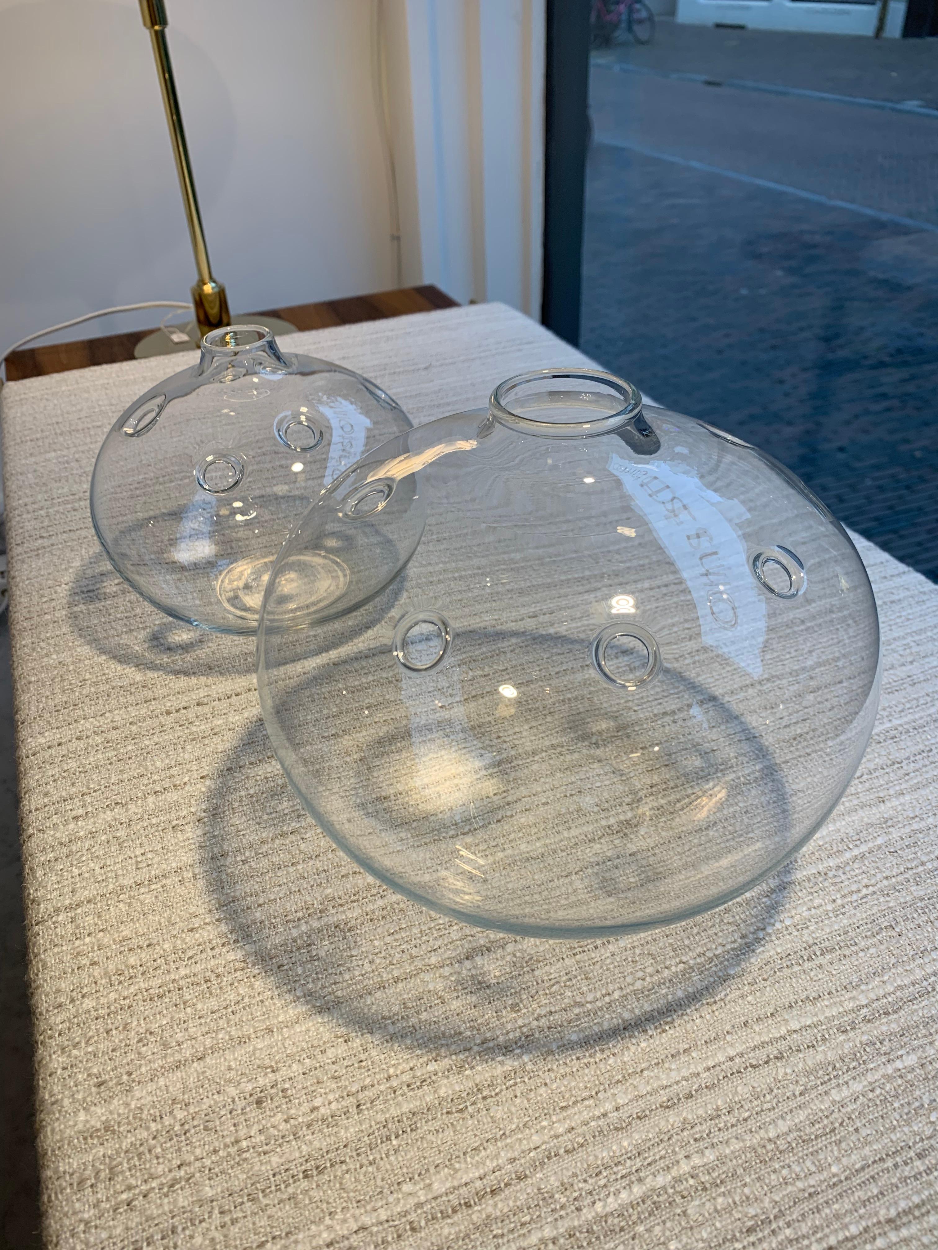 Pair of mouth blown clear glass Hull (hole) vases, designed by Michael Bang for Holmegaard Denmark, 1970s. Produced between 1973-1978.
Vases are executed with multiple holes to place and arrange flowers in, Ikebana style. 

This is the largest size
