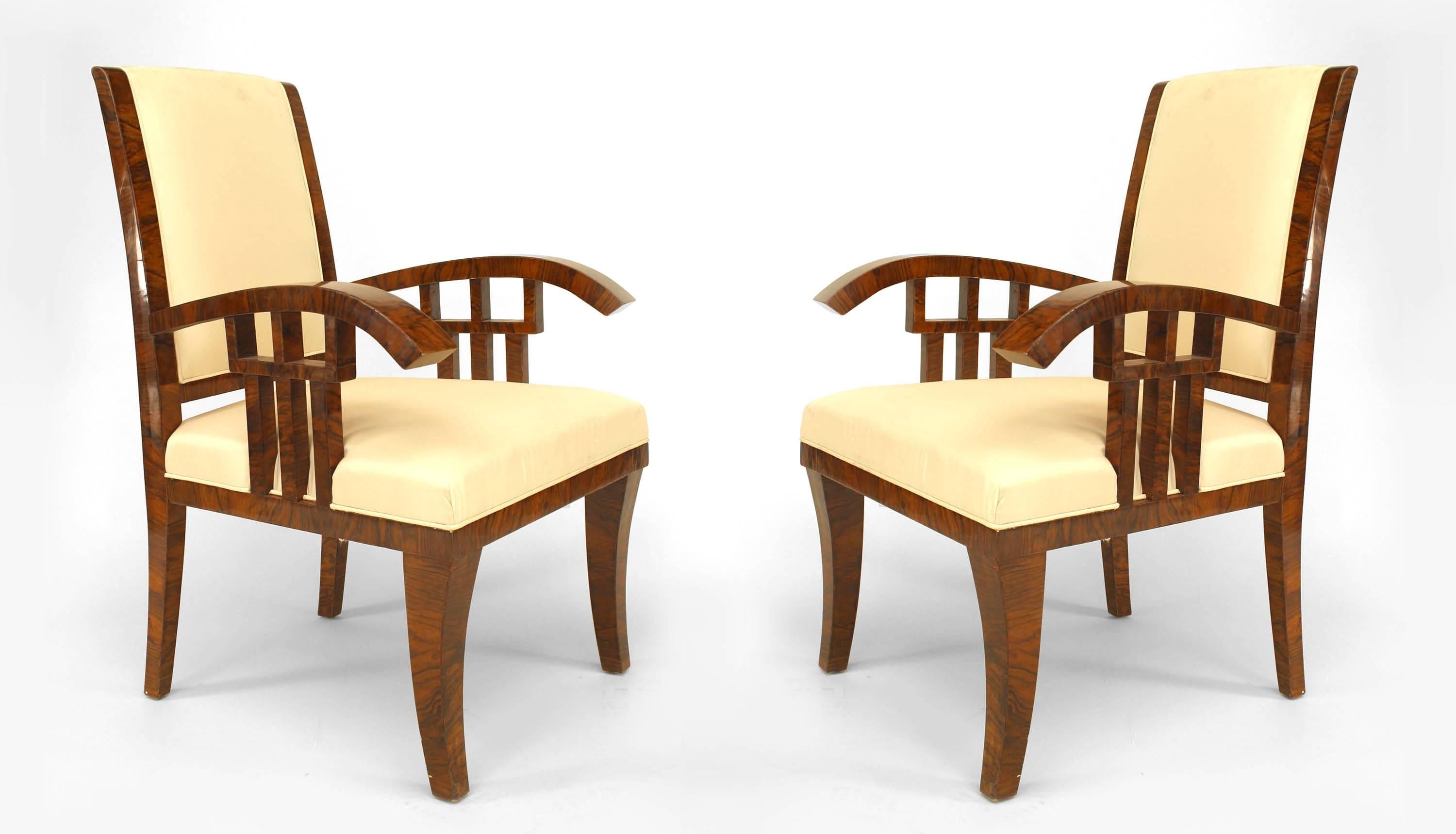 Pair of Hungarian Art Deco walnut armchairs featuring geometric open design underarms, seats and backs upholstered in cream fabric, and square tapered leg supports. Attributed to Lajos Kozma.