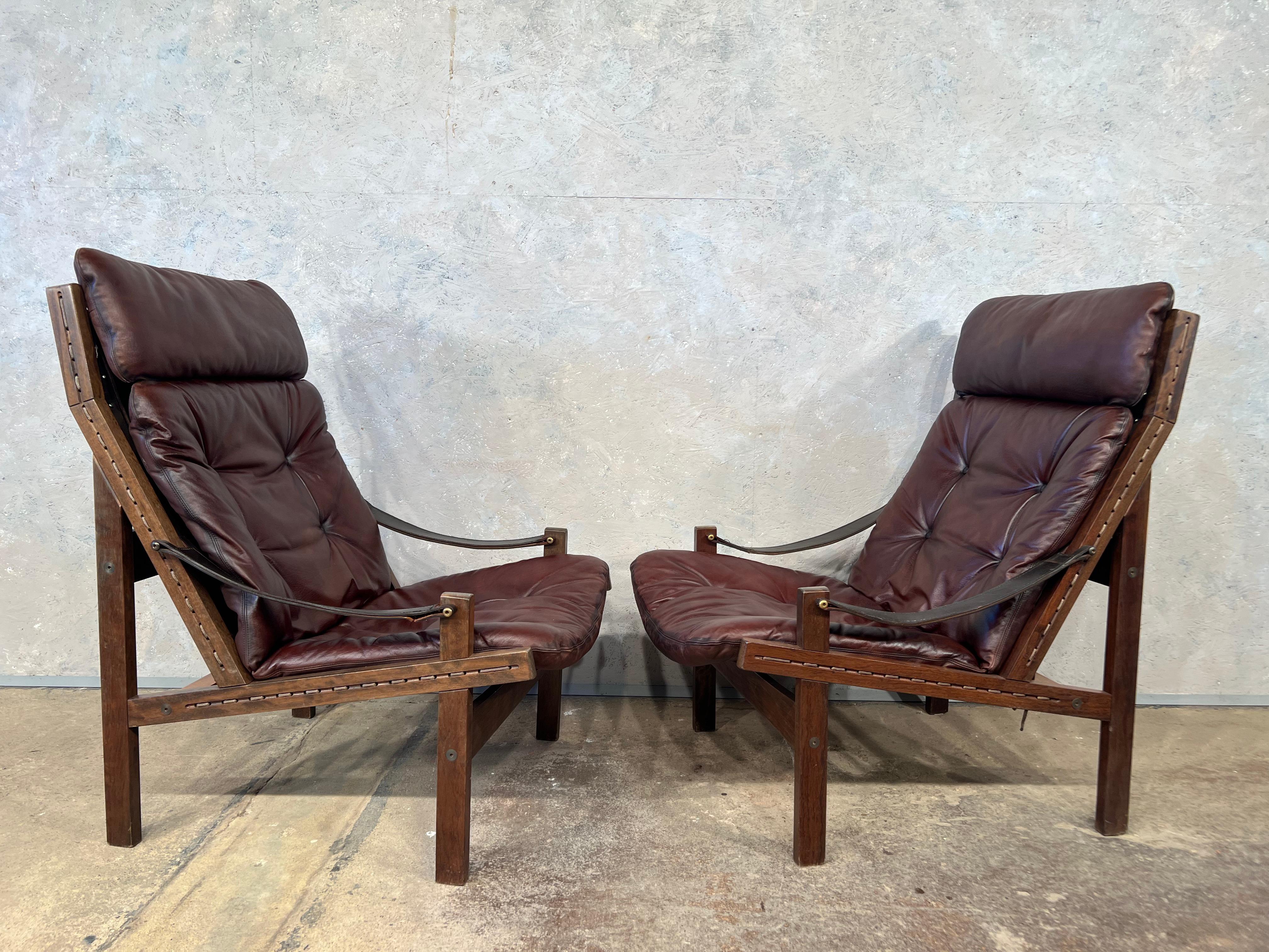 A pair of Hunter lounge chair with rich brown leather and solid Rosewood frame. Canvas weave holding the leather cushion up. Designed in the 1960s by Norwegian Torbjørn Afdal for Bruksbo.

Good vintage condition. Patinated with signs of wear