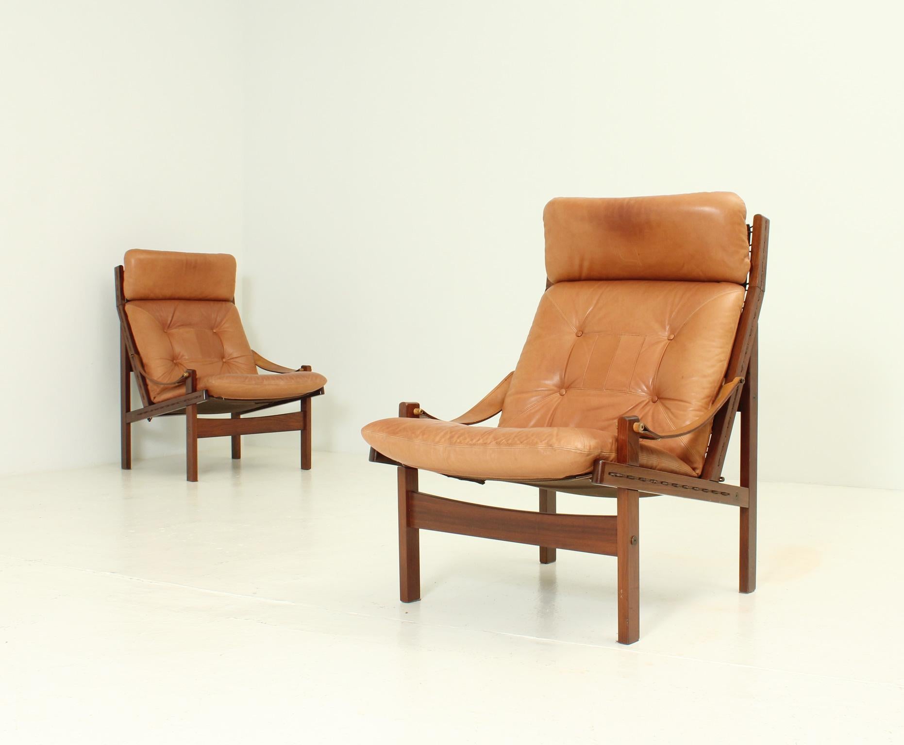 Pair of Hunter lounge chairs designed in 1960's by Torbjørn Afdal for Bruksbo, Norway. Tropical wood frame with canvas seat and original leather cushions and strabs.