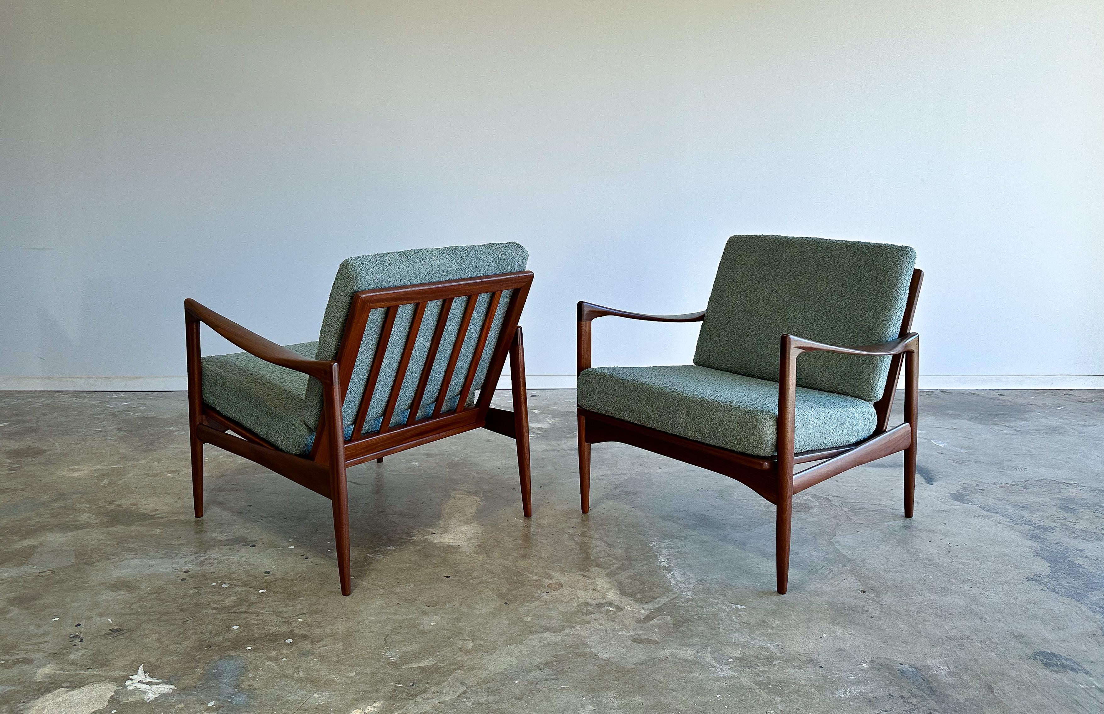 Offered is a beautiful pair of lounge chairs designed by Ib Kofod Larsen and made by Illums Bolighus circa 1960.

Referred to as the Kandidaten or Candidate model, these chairs feature solid afromosia teak construction with lovely sculpted armrests.
