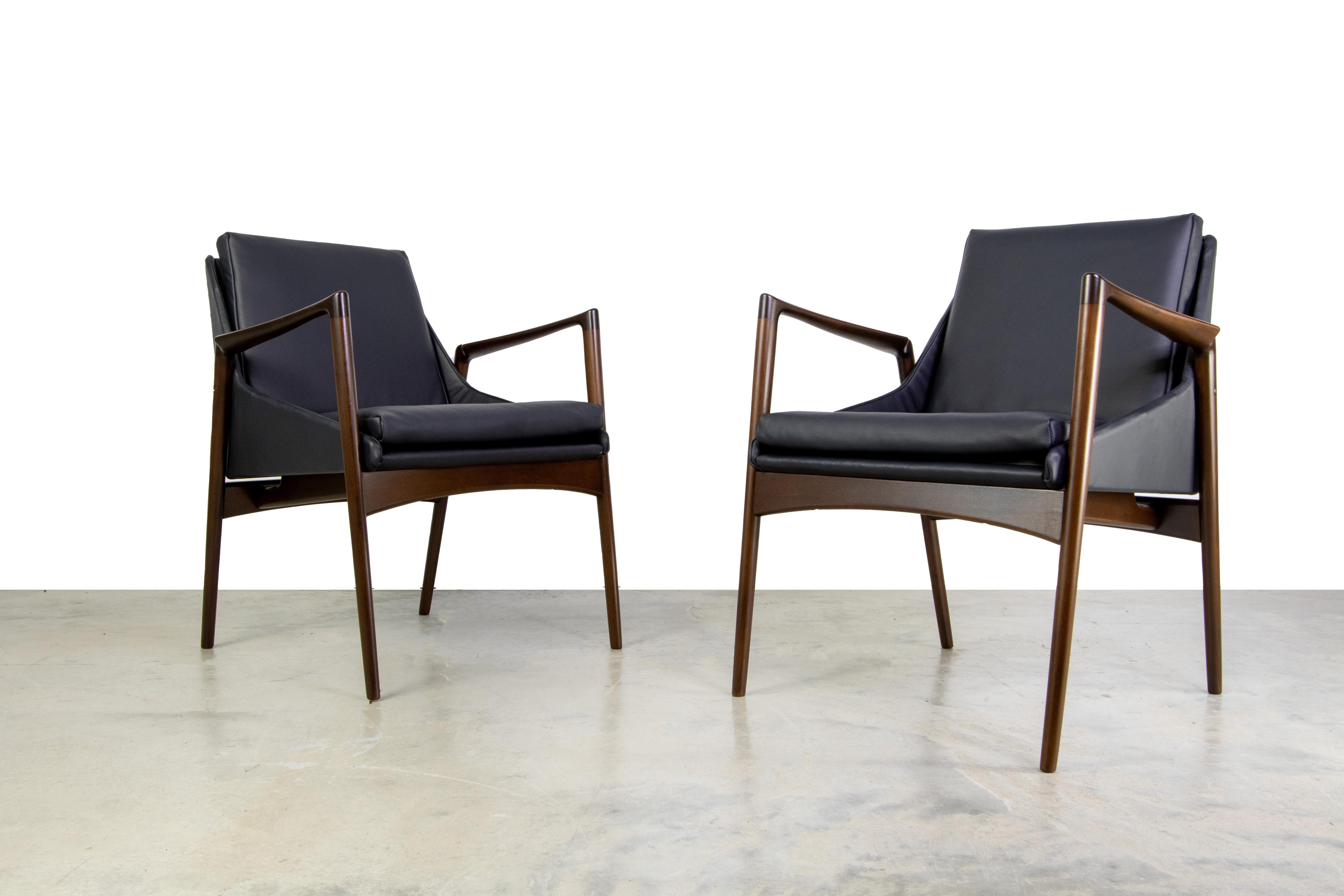 Pair of Ib Kofod Larsen for Selig Lounge chairs. These chairs are a smaller scale and would work well in a living room as well as in front of a desk. The sculpted frames are made of solid beech stained in a dark walnut. The foam was replaced and the