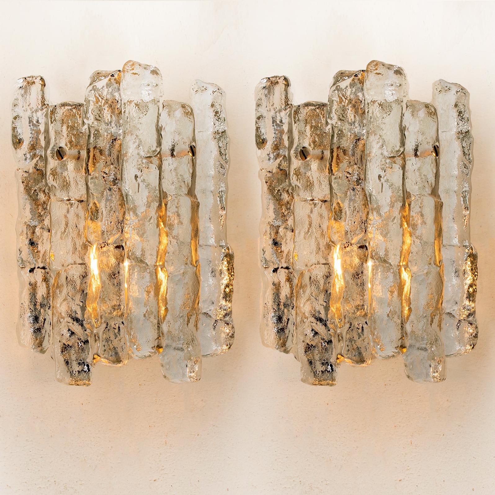 Pair of four beautiful and elegant modern brass wall lights or sconces, manufactured by J.T. Kalmar Austria in the 1970s. Lovely design, executed to a very high standard. 

Each wall light has two solid ice glass sheets dangling on it. Clean lines