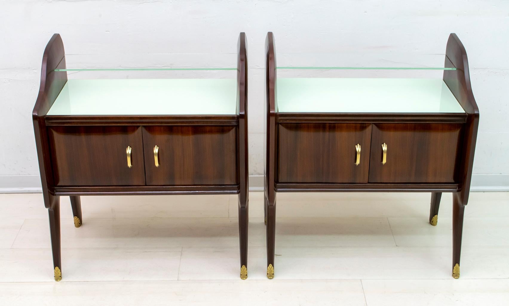 Pair of bedside tables designed by the famous architect Ico Parisi, in walnut wood, glass shelves and brass finishes. They have been completely restored, as can be seen in the photo.