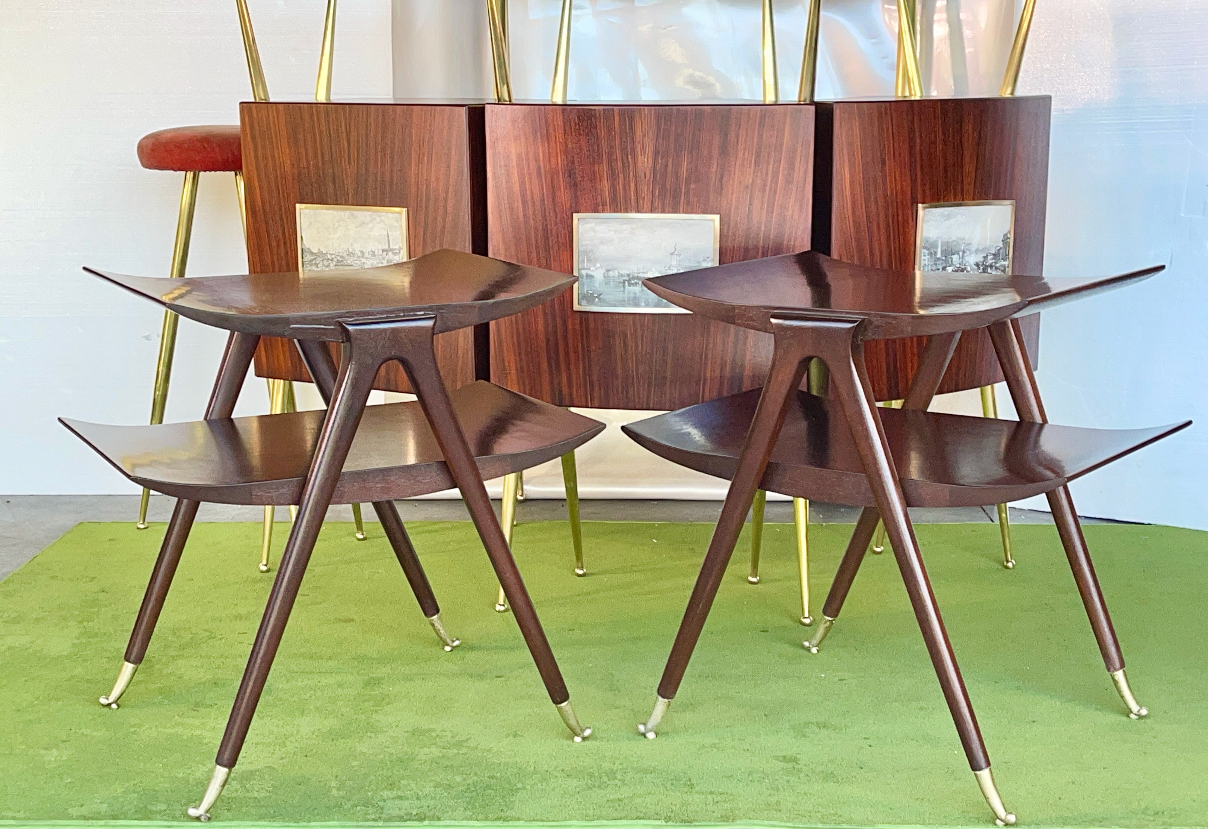 Dramatic vintage pair of bi-level tables in the style of Ico and Luisa Parisi. 
Finely constructed of walnut hardwood and veneer, both tiers feature upswept ends and are supported by strikingly elegant tapered legs which stand on dainty solid brass