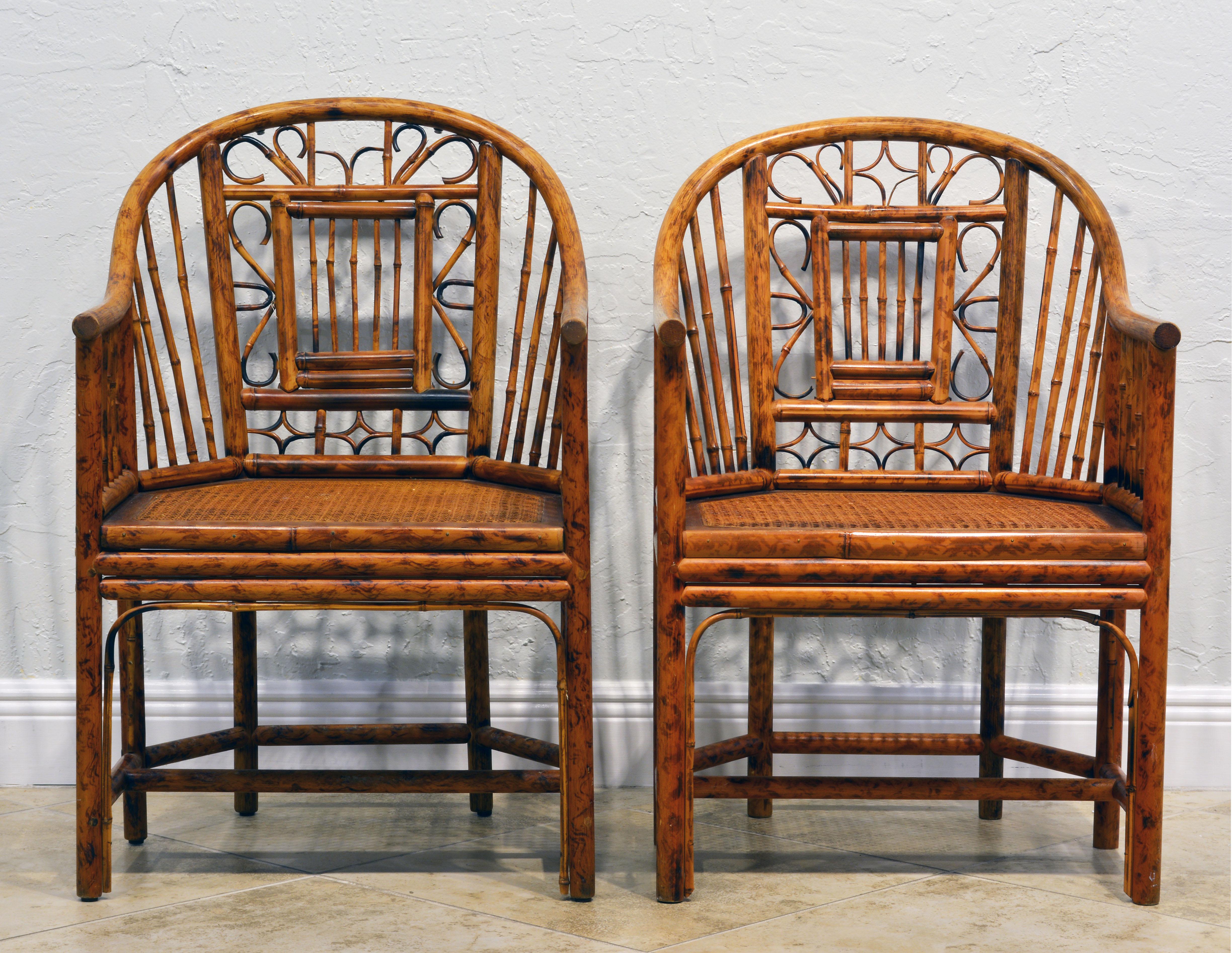 These iconic Brighton Pavilion style chinoiserie bamboo arm chairs are made of burnished bamboo with beautifully detailed backs and cane seats. They rest on six legs united by stretchers.
