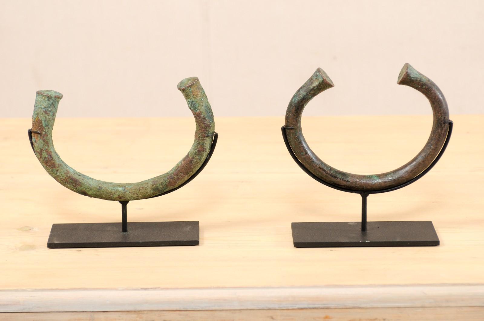 A pair of African manilla trade currencies from the Igbo People of Central Nigeria, West Africa. Manilla bracelets (a form of money) were commonly used throughout Nigeria and surrounding areas for centuries to purchase slaves, ivory, and other trade