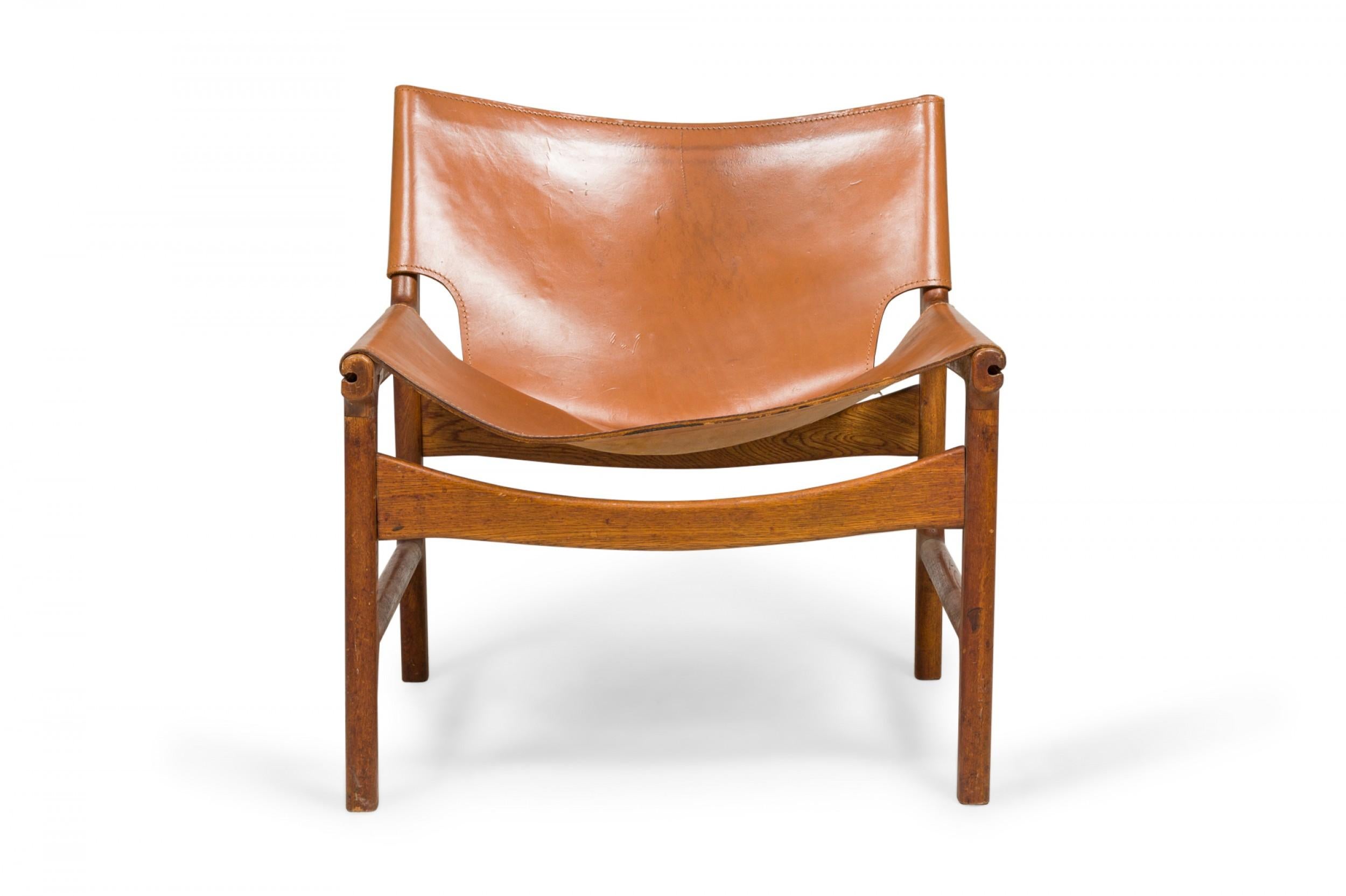 Mid-Century Modern Pair of Illum Wikkelsø Caramel Leather and Oak Sling Design Lounge Chairs