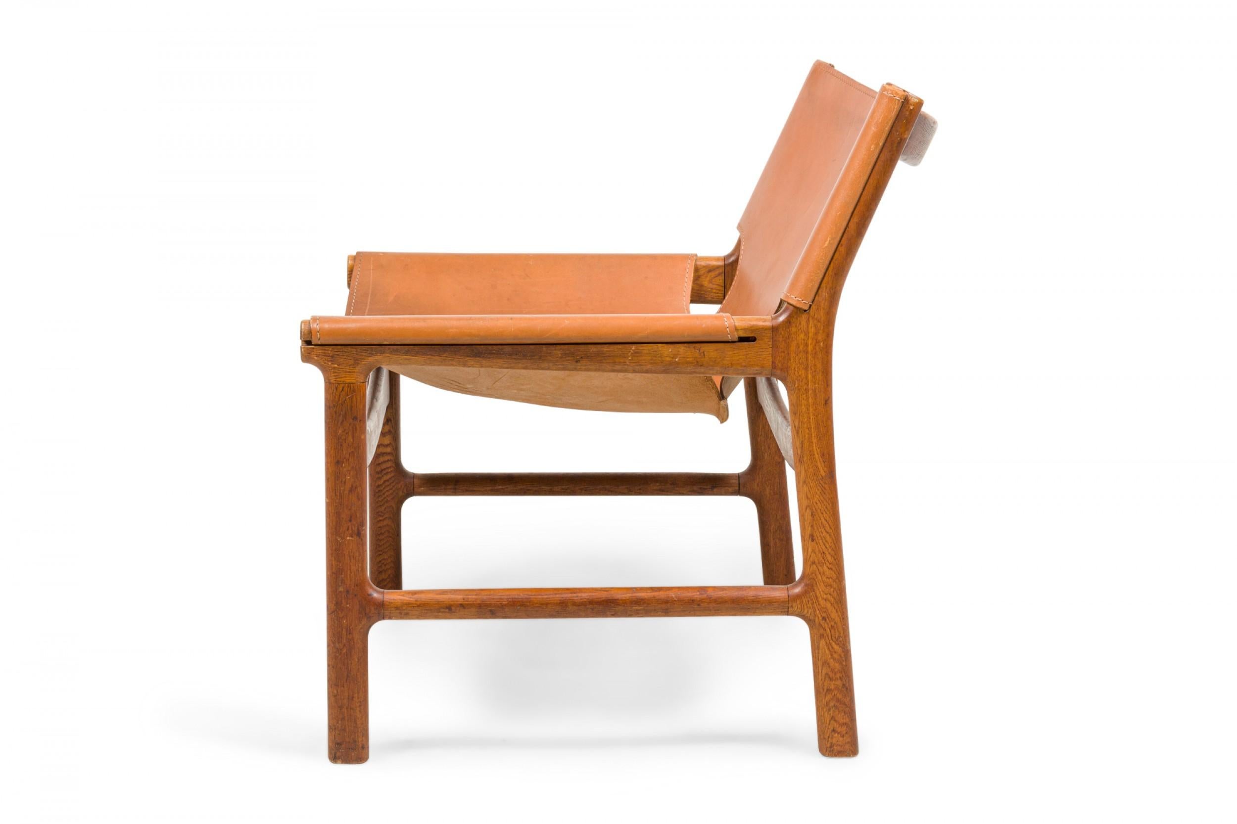 Pair of Illum Wikkelsø Caramel Leather and Oak Sling Design Lounge Chairs In Good Condition In New York, NY