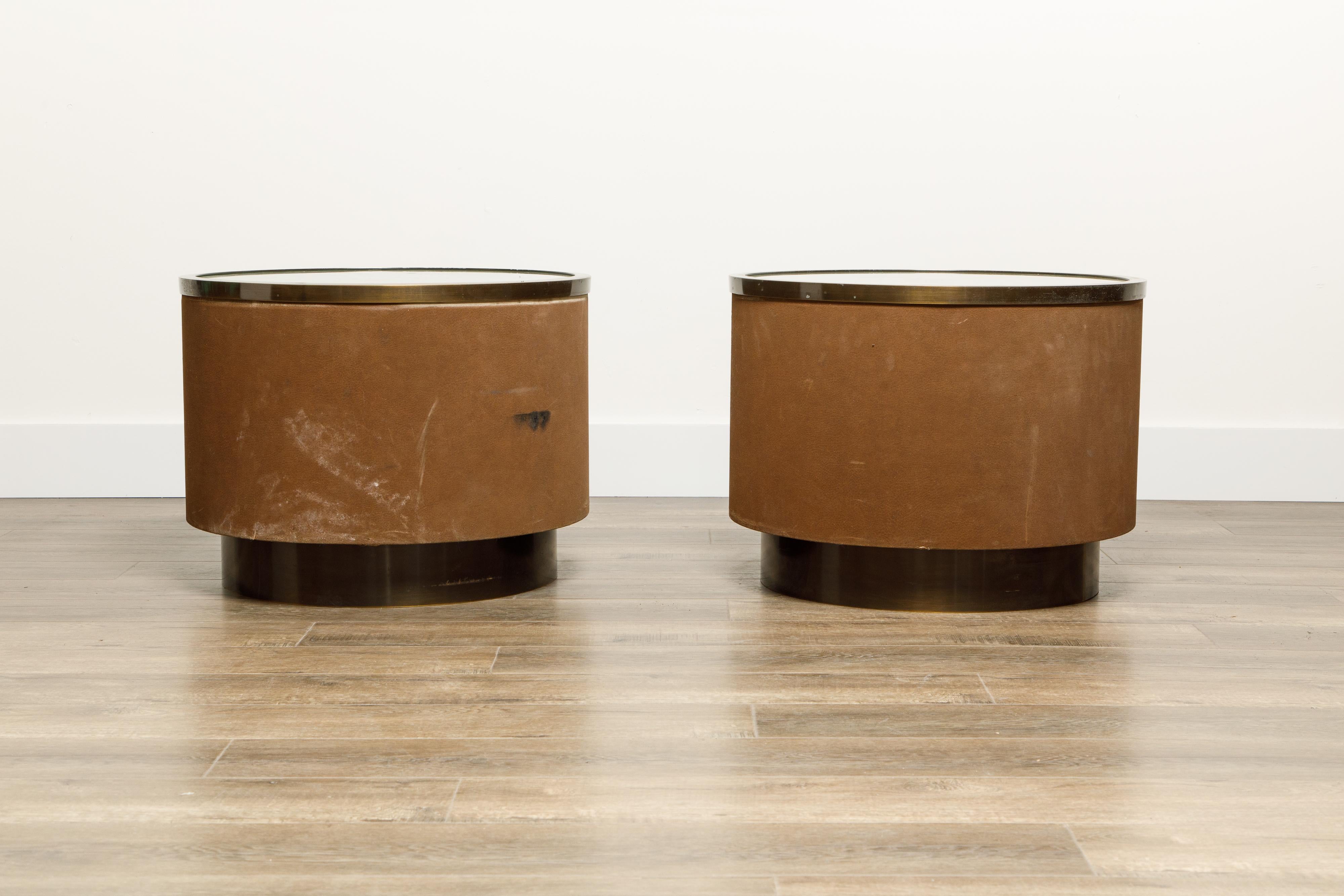 A unique pair of illuminated suede drum side tables by Steve Chase, circa 1980s. This pair of side tables came from a Steve Chase designed home and features suede leather wrapped around he cylindrical frame with metal rim and frosted glass top on