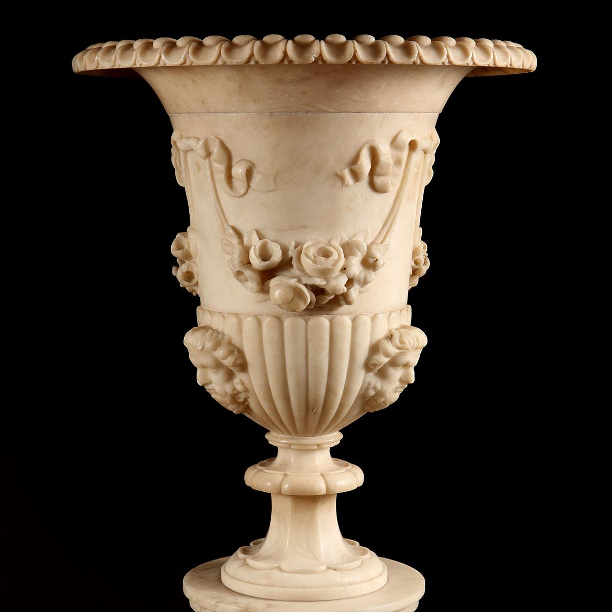 Floor standing classically carved alabaster vases on fluted columns and square stepped pedestals

Carved with Satyre masks and foliate swags suspended from ribbons
Electrified and Illuminated throughout, including the base, the column, and the